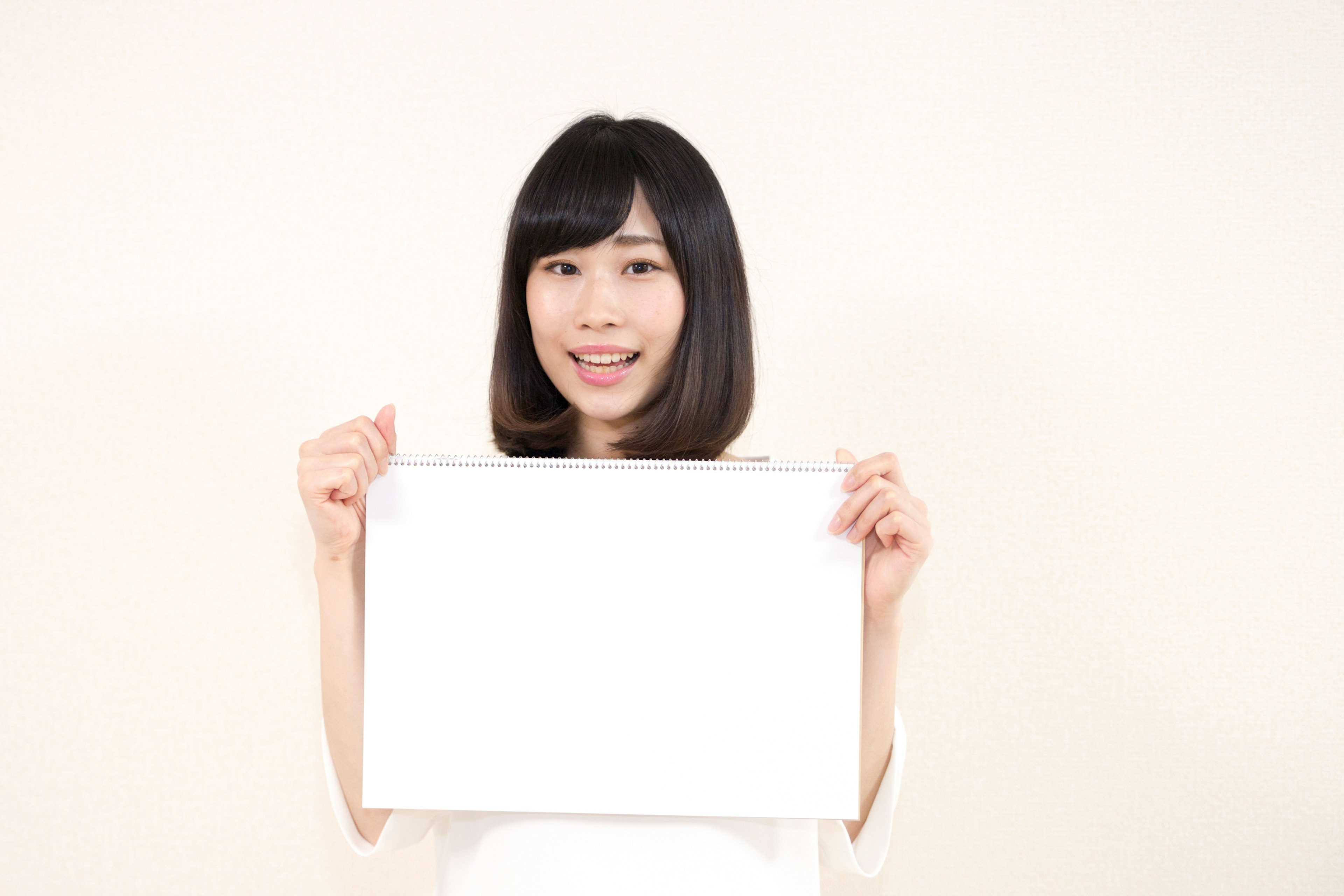 Smiling woman holding a blank white board