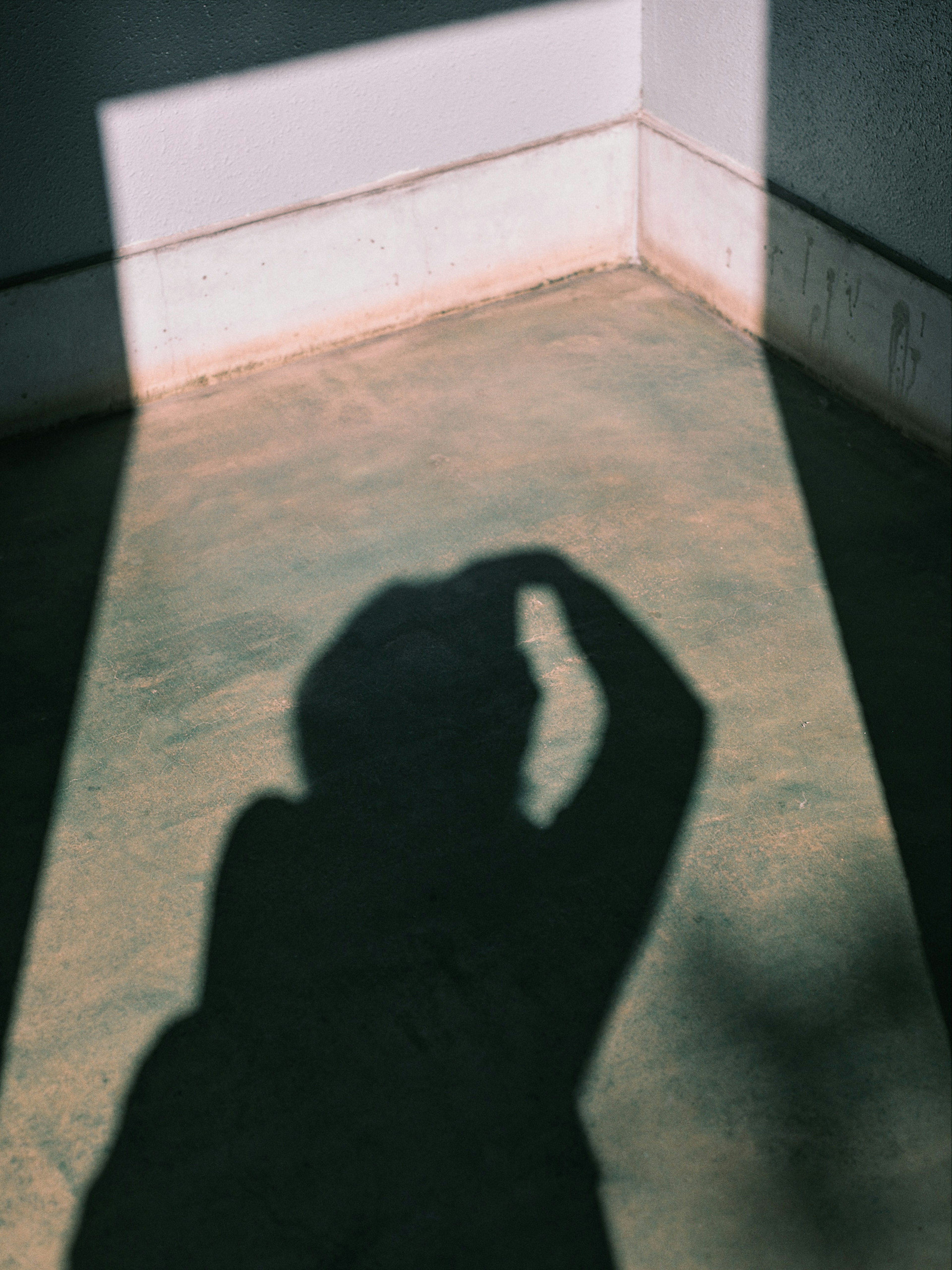 A shadow cast on the floor in a quiet corner