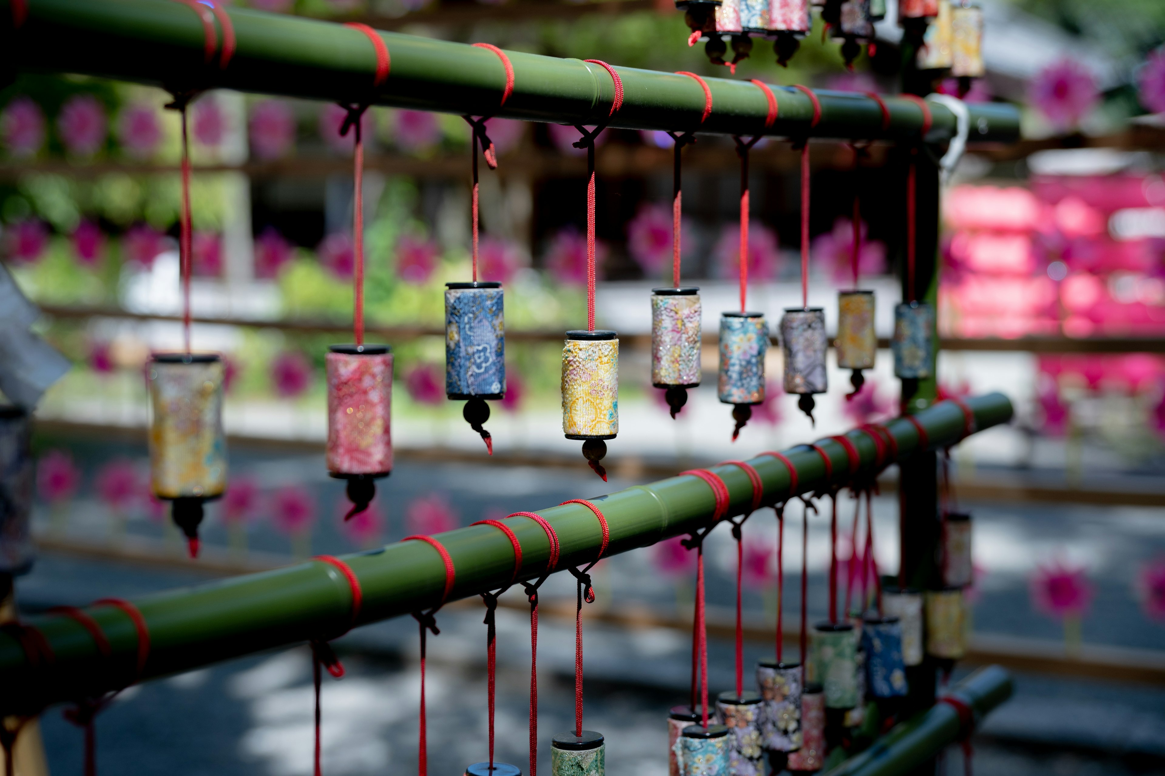 Colorful small bells hanging from a bamboo frame