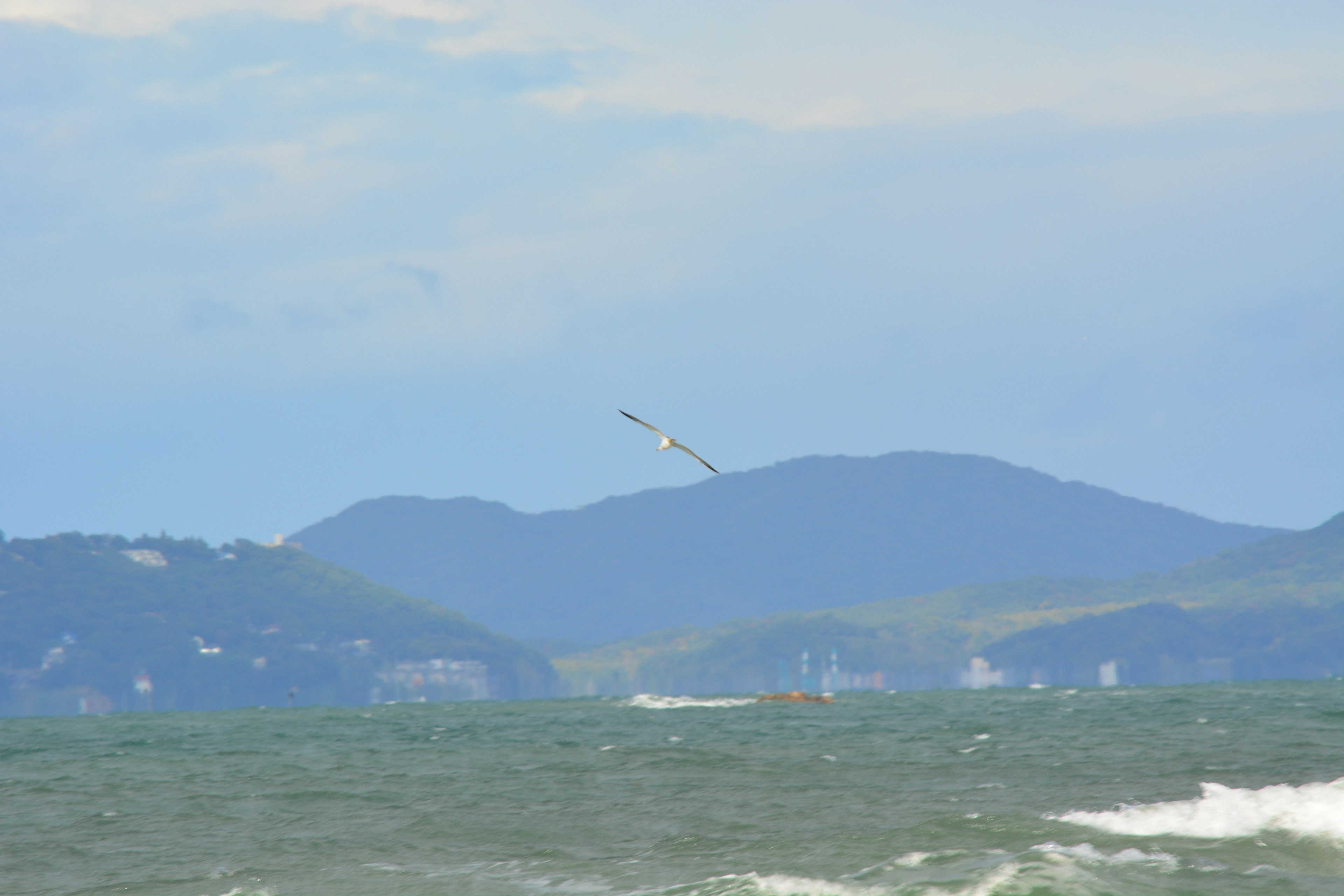 海景，远处有蓝色海水和山脉，船只可见