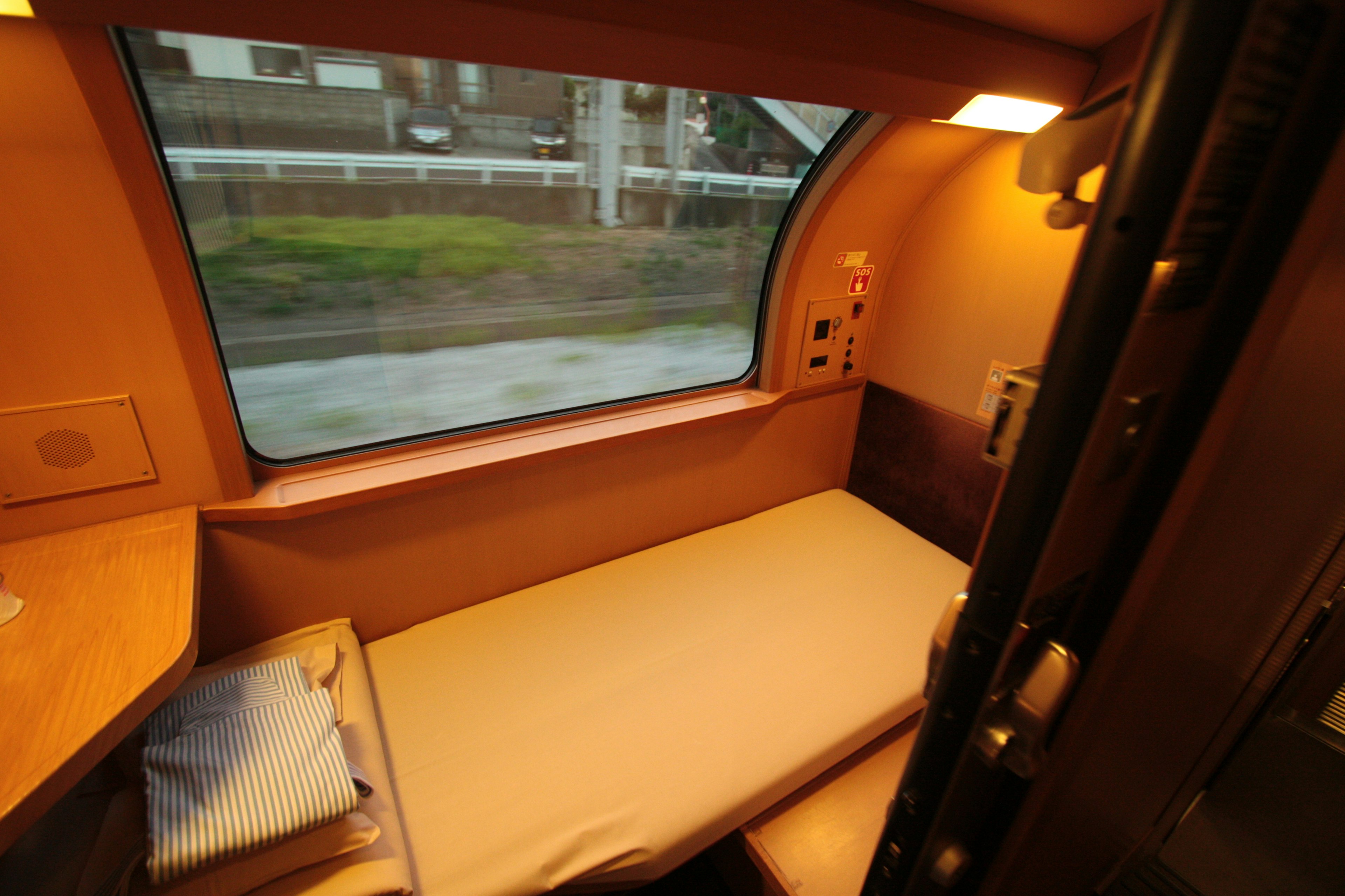 Compartimento de tren con cama y gran ventana con vista