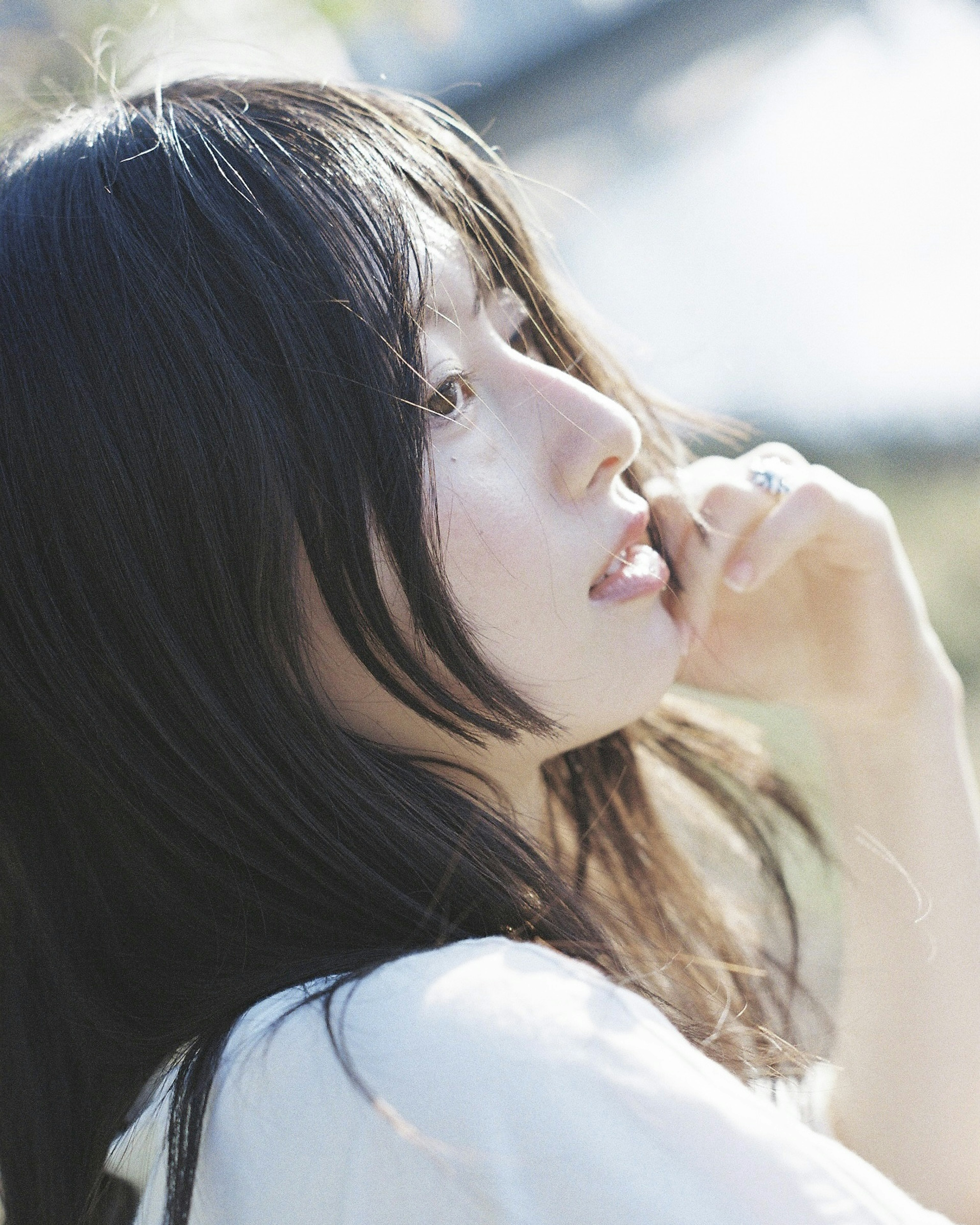 Profile of a woman smiling in natural light with delicate hair and a soft expression