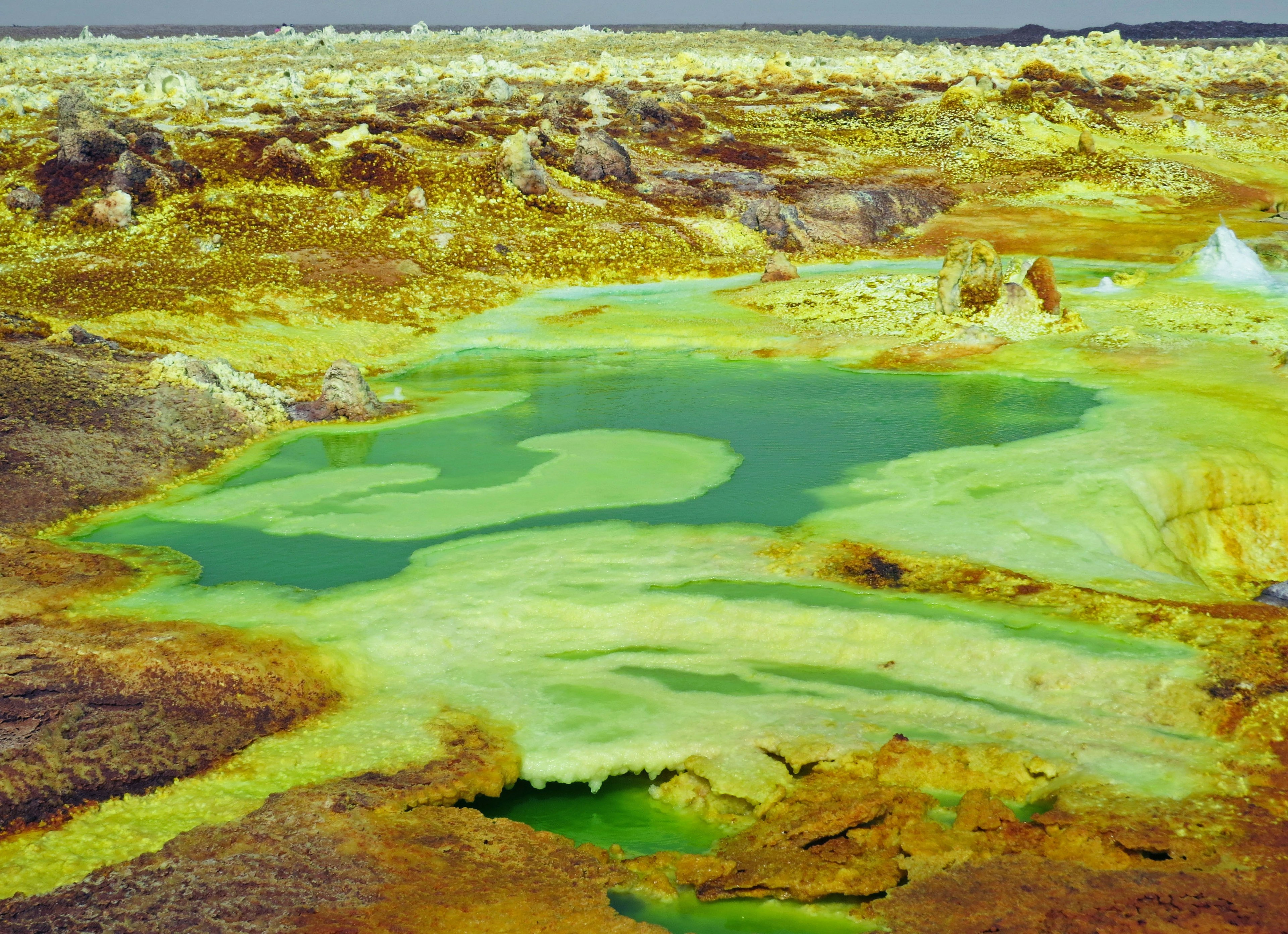 Green lake in the Danakil Desert of Ethiopia with yellowish terrain