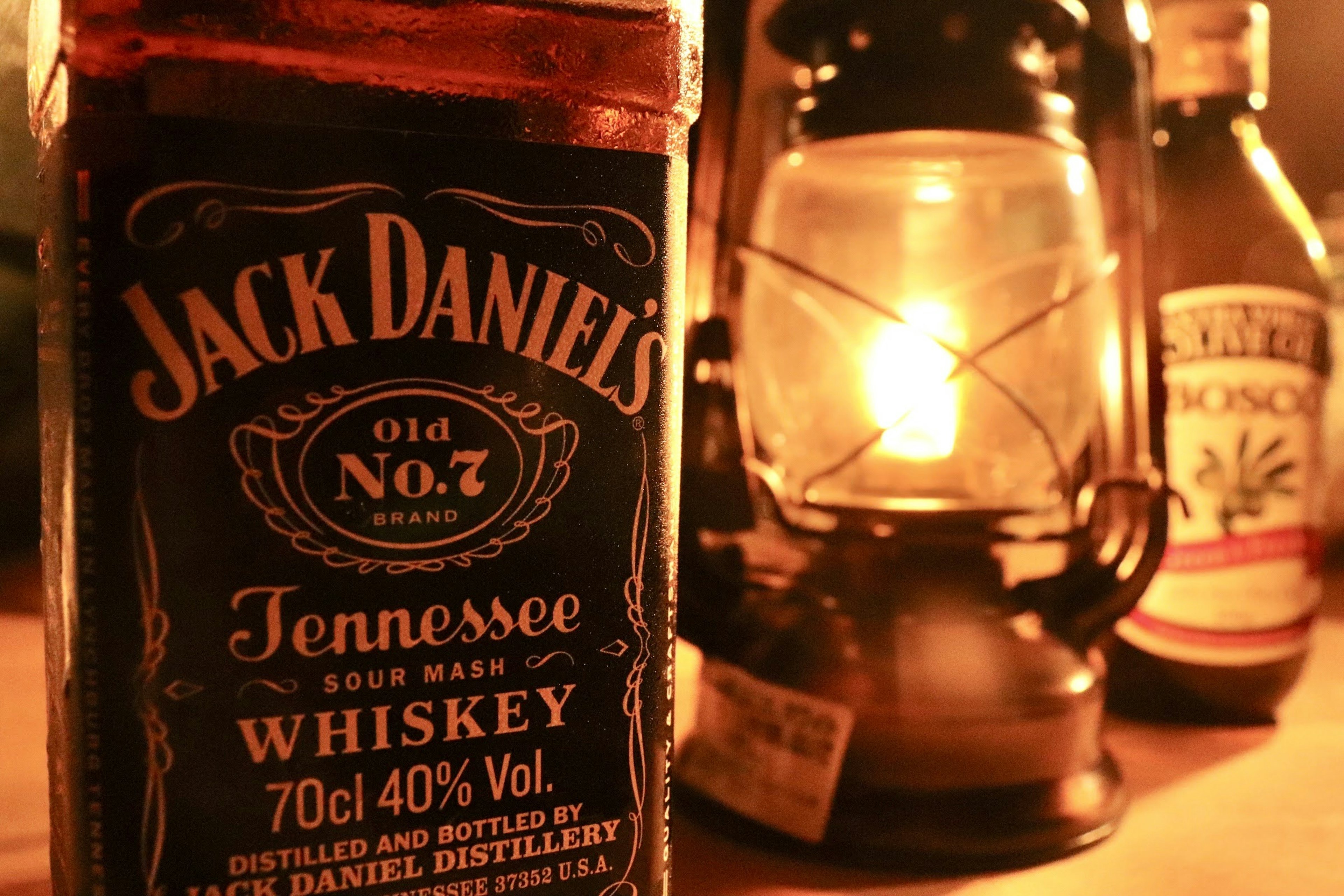 Jack Daniel's whiskey bottle with a lantern in a warm setting