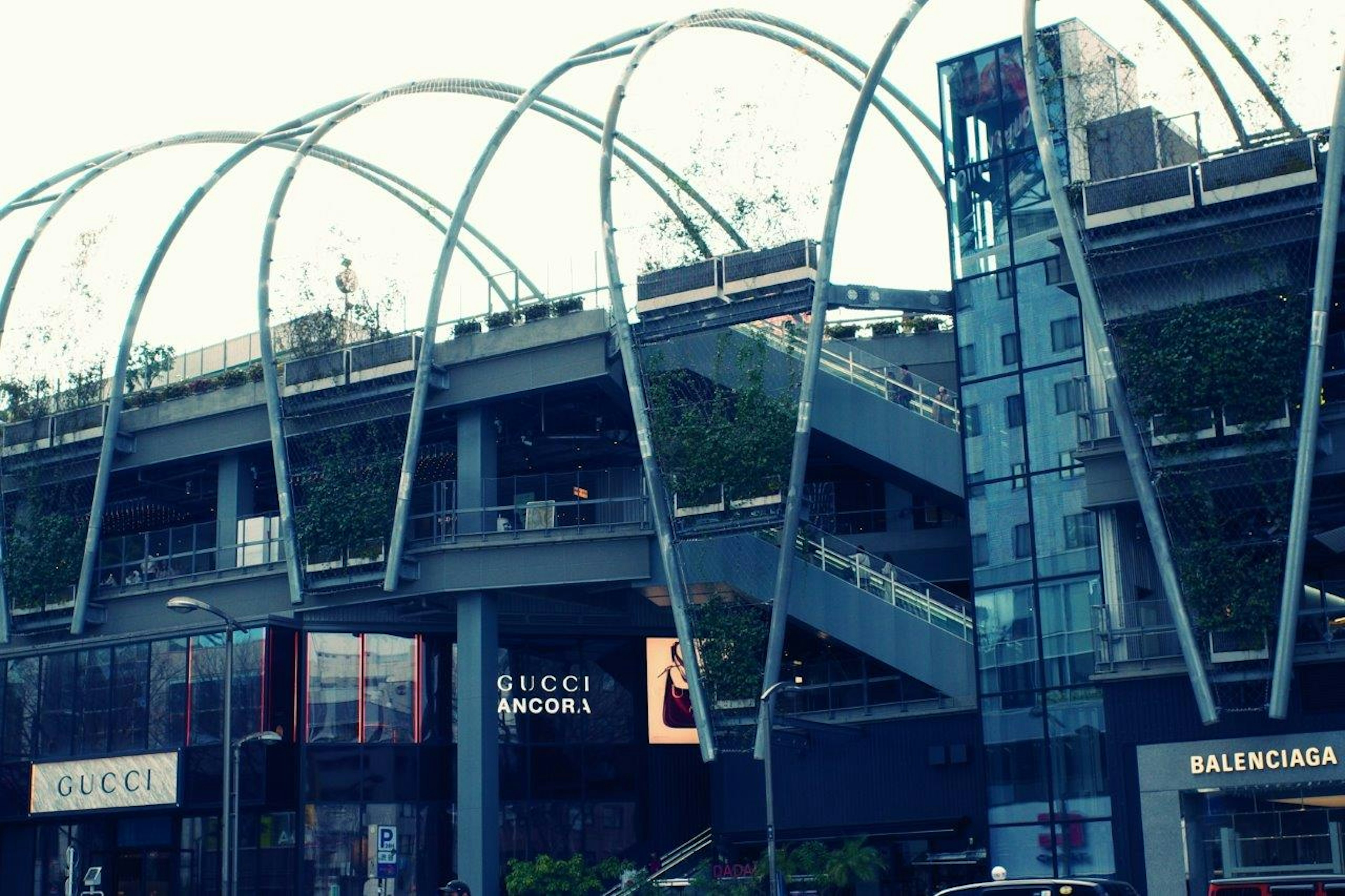 Exterior de un centro comercial moderno con tiendas Gucci y Balenciaga