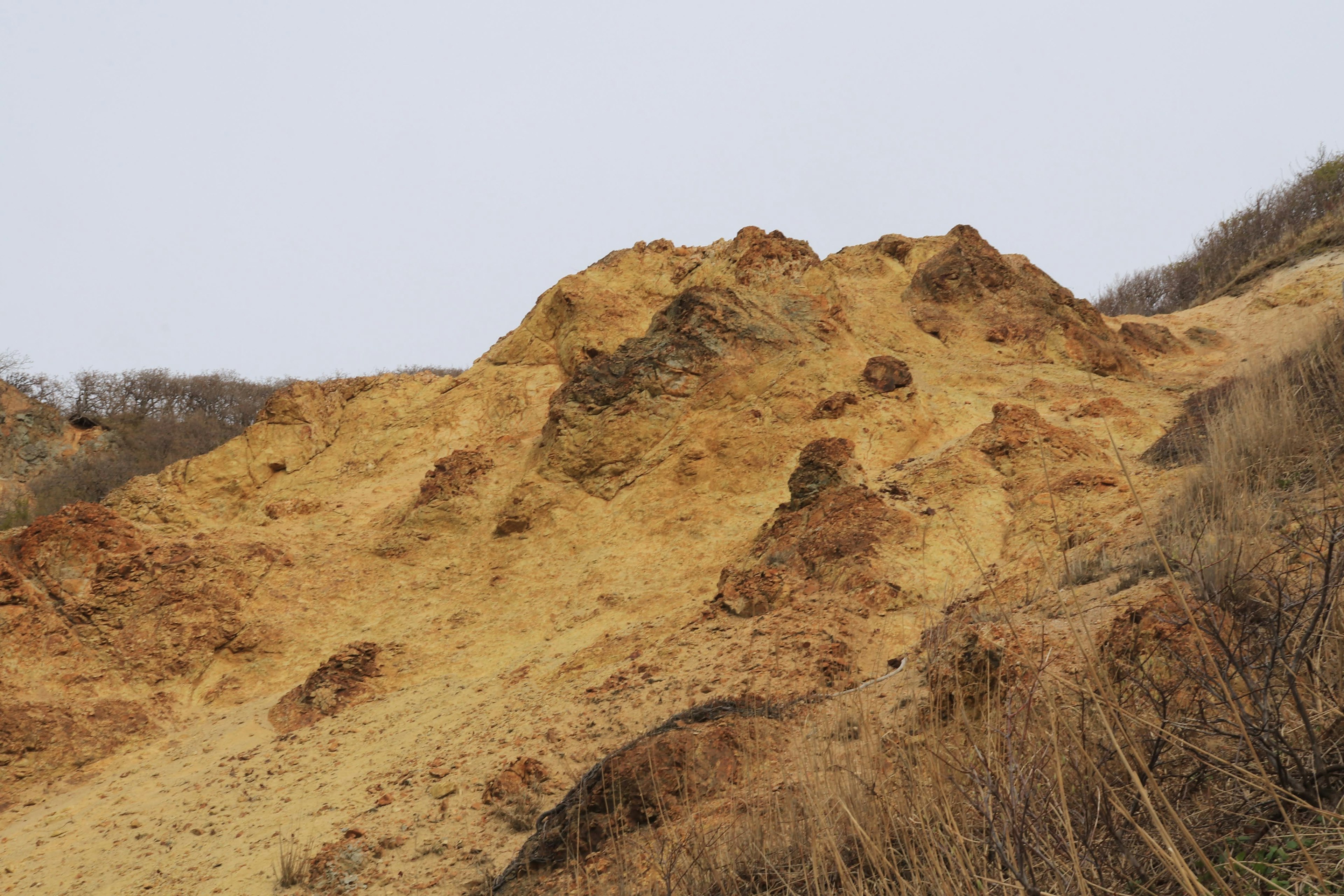 Hilly terrain with sandy slopes and sparse vegetation