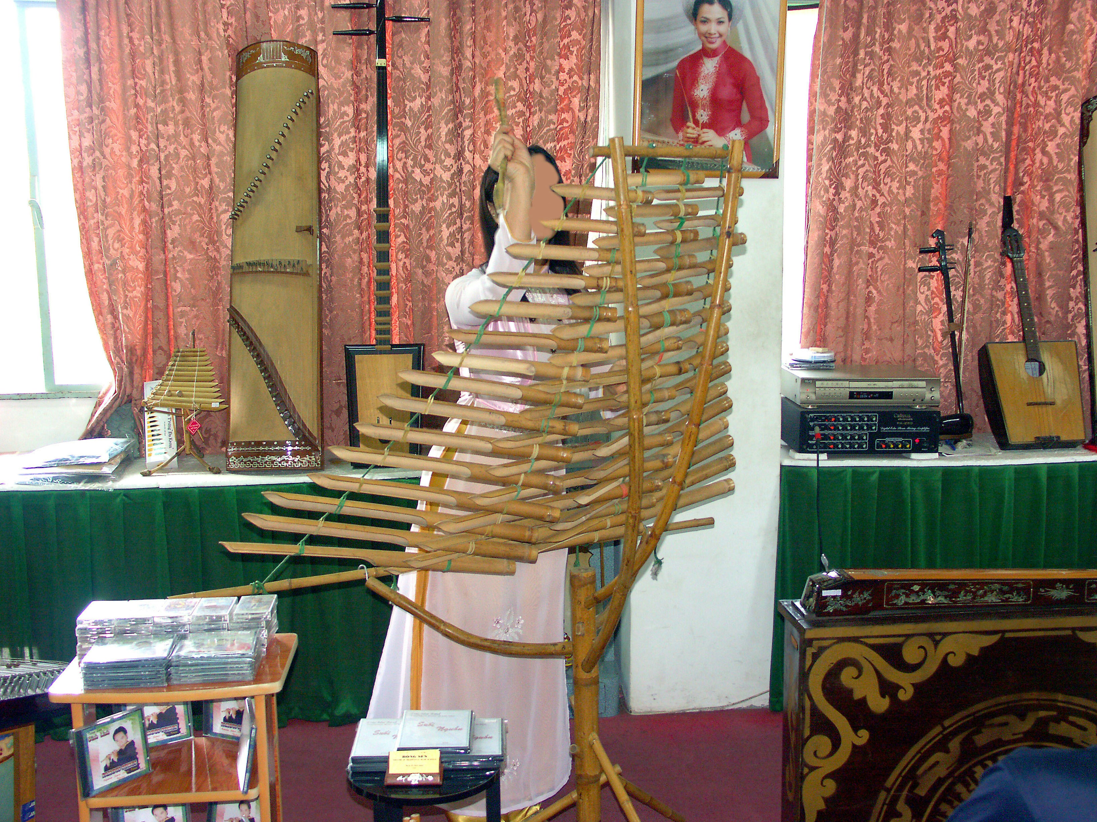 A performer with a bamboo musical instrument in a display room