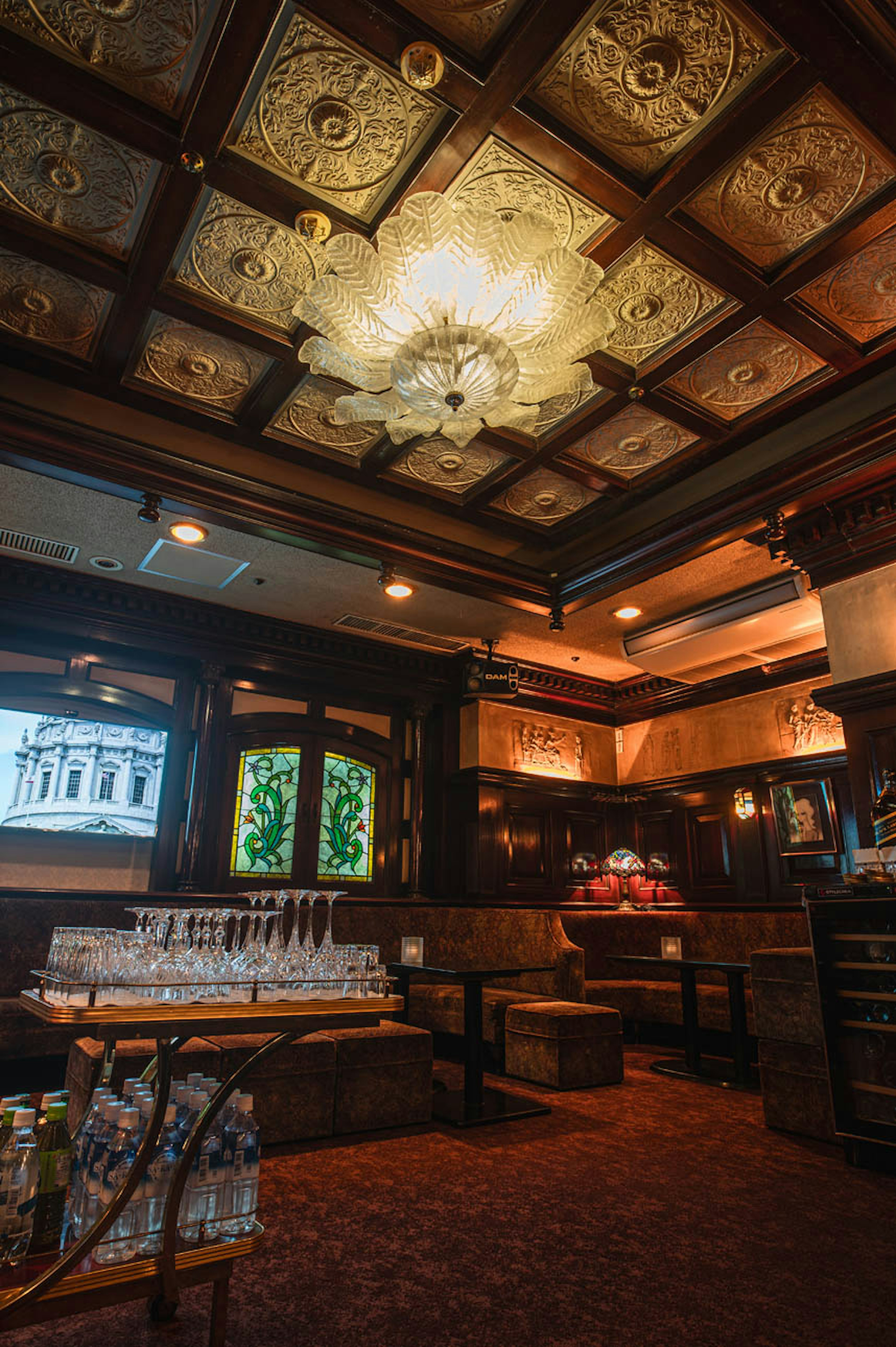 Interior de un bar con techo ornamentado y decoración vintage