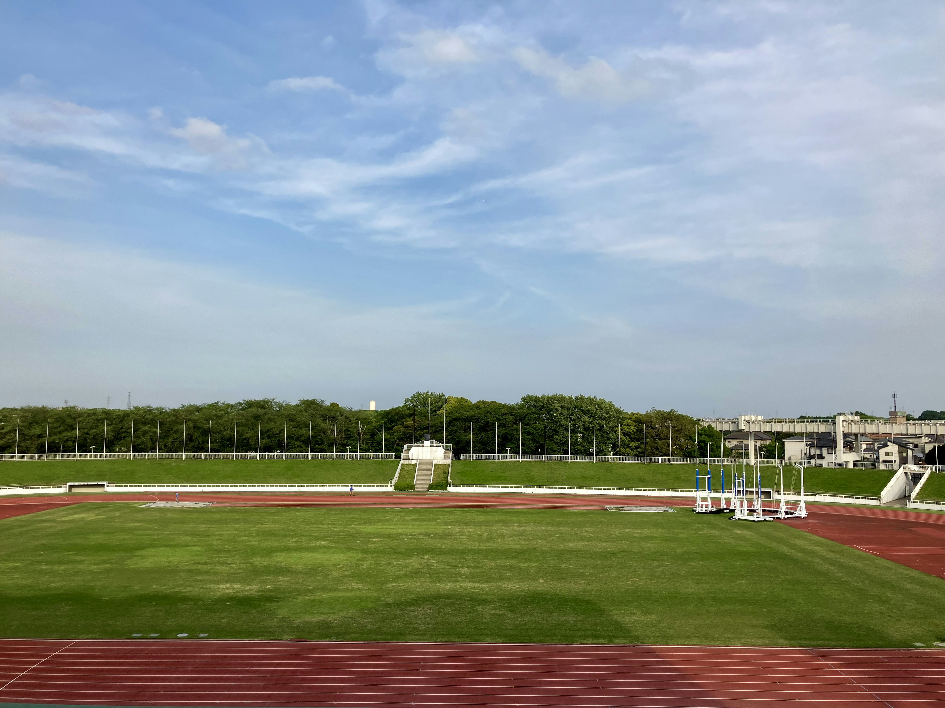 Lapangan atletik dengan rumput hijau dan langit biru