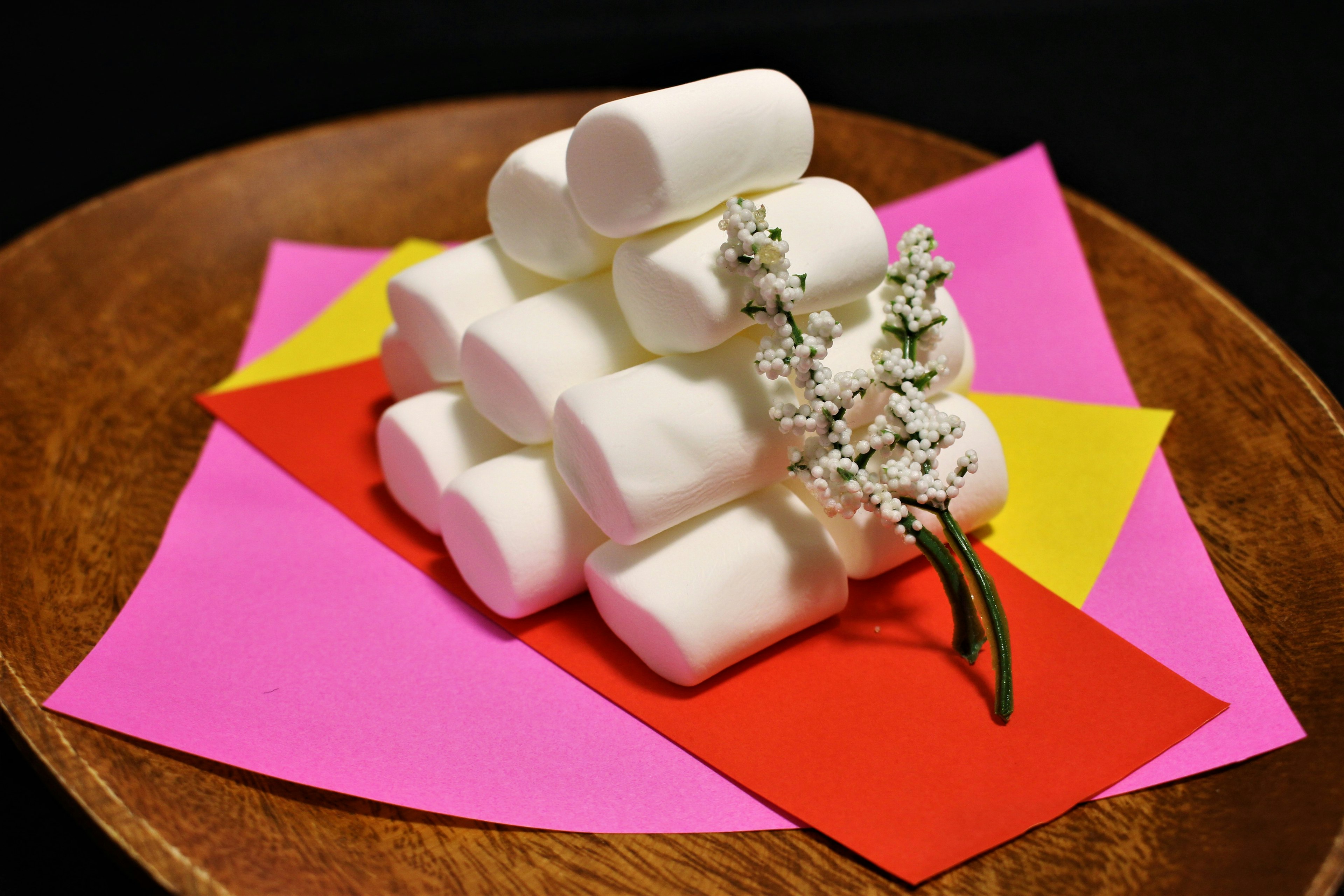 A pyramid of white marshmallows on colorful paper backgrounds