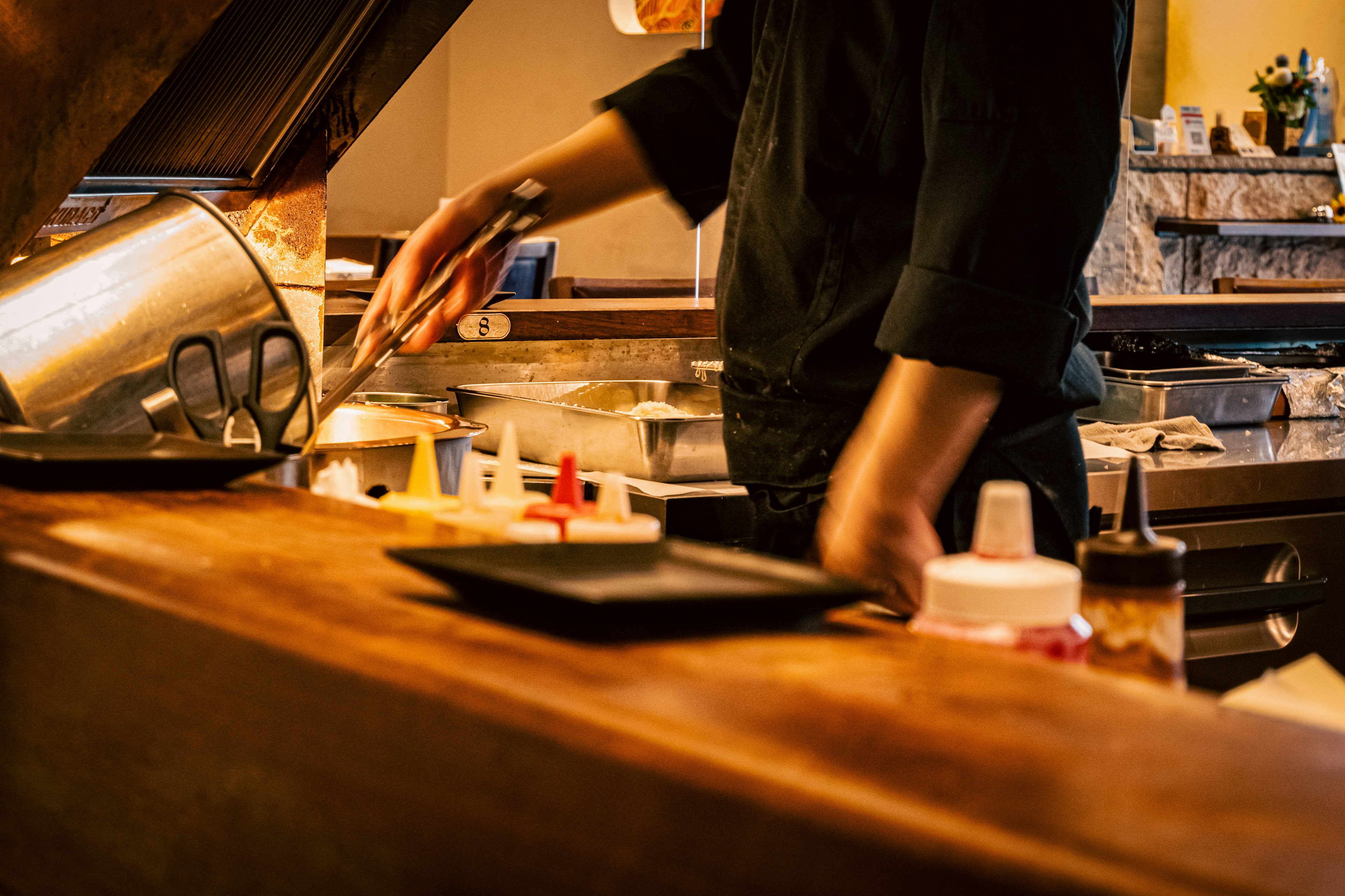 Chef cooking in a kitchen scene with cooking utensils and condiments visible