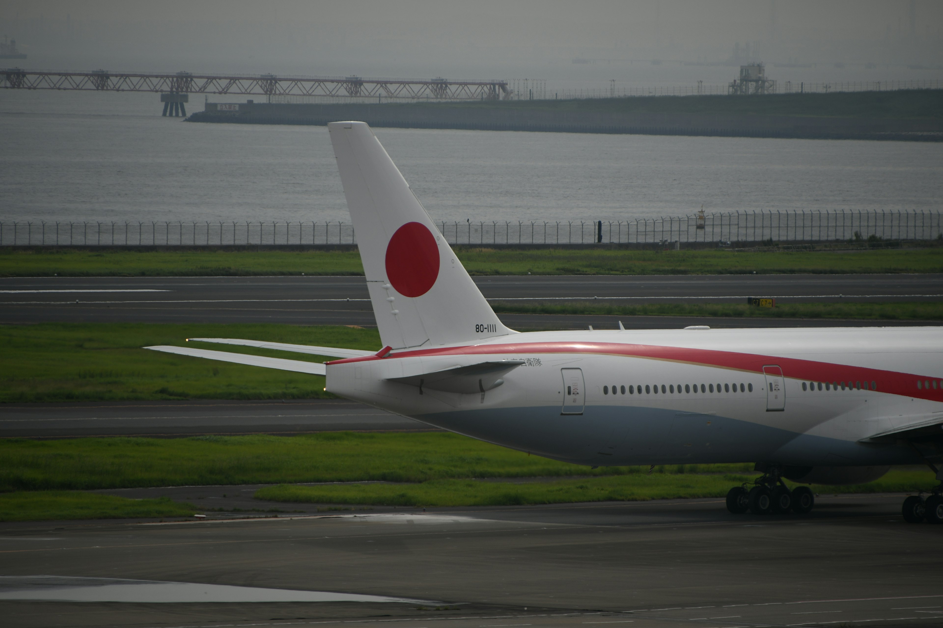 日本航空の飛行機の尾翼が滑走路に停まっているシーン