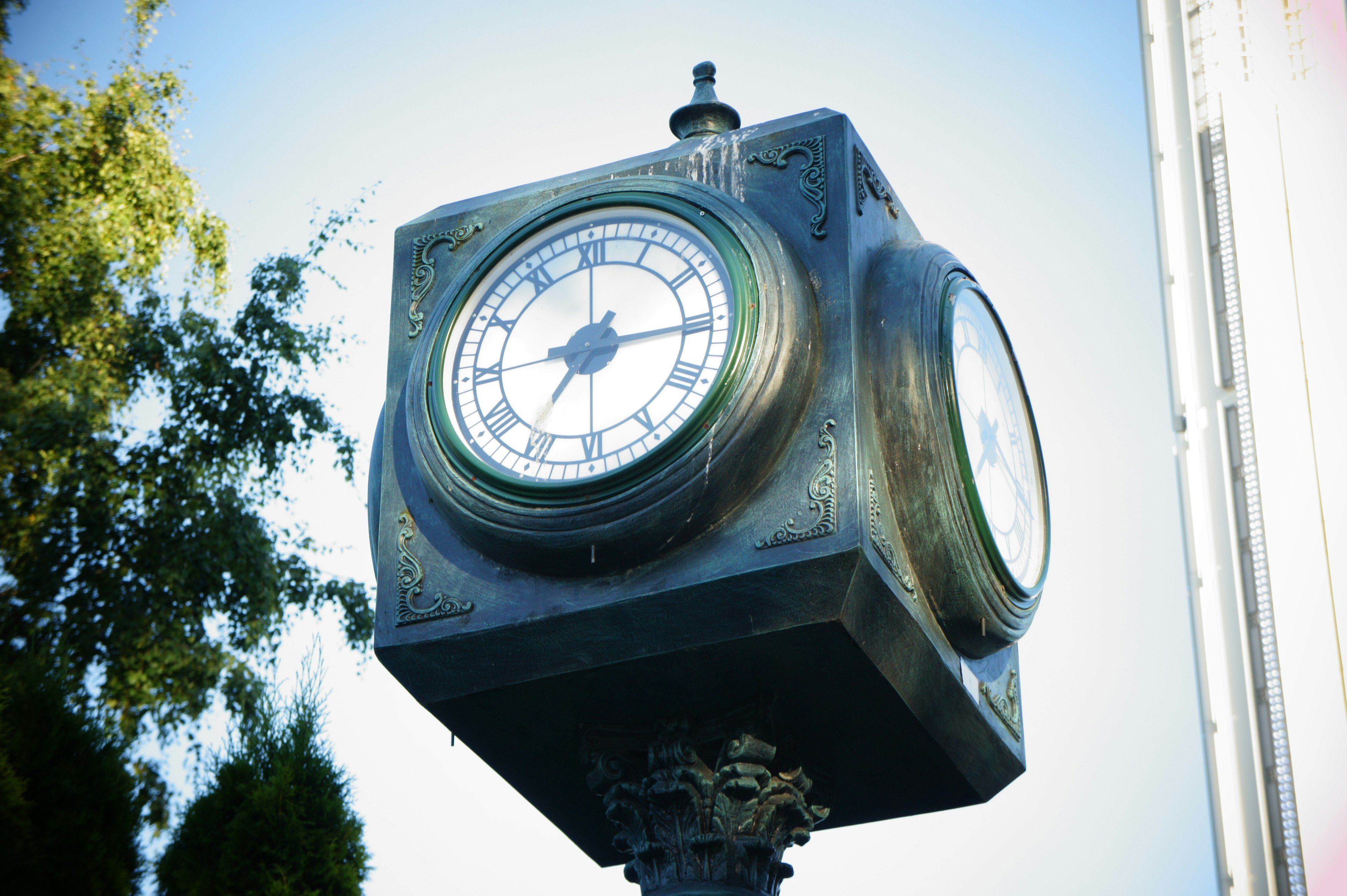 Reloj de calle cuadrado con diseño vintage bajo el cielo azul