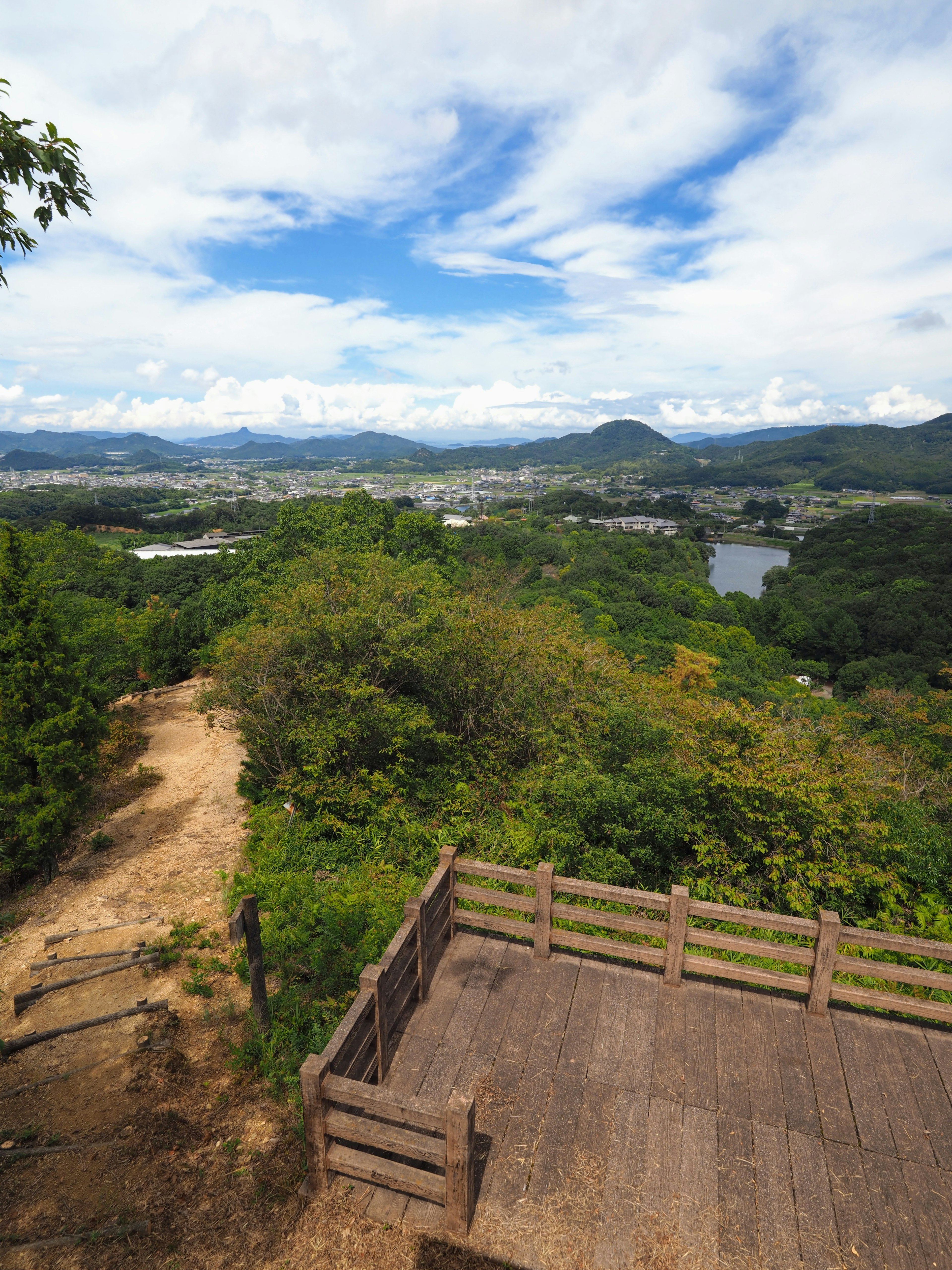 從山坡上俯瞰的風景，郁郁蔥蔥的綠樹、山脈和河流在晴天中可見