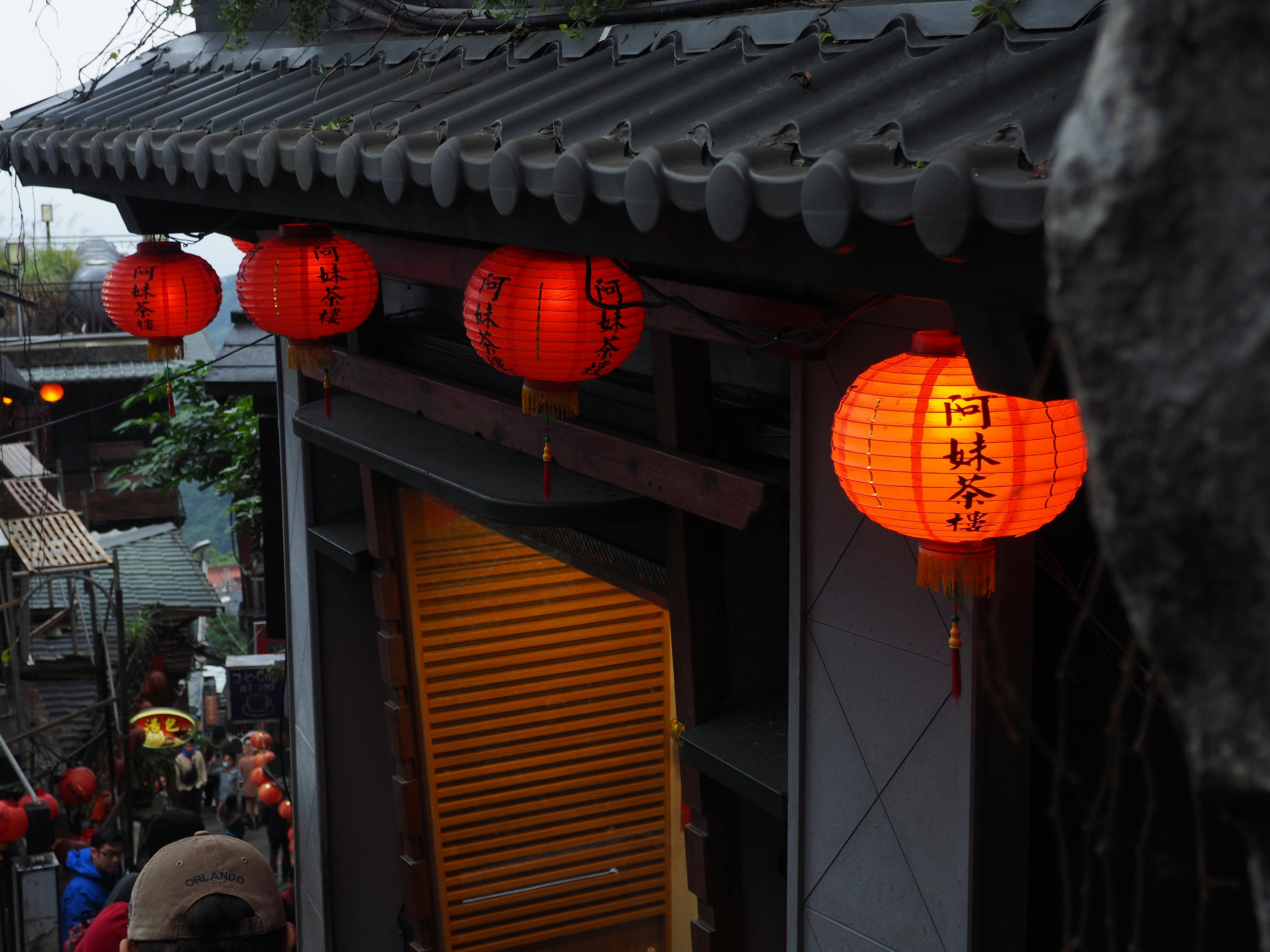 Part of an old building roof adorned with red lanterns