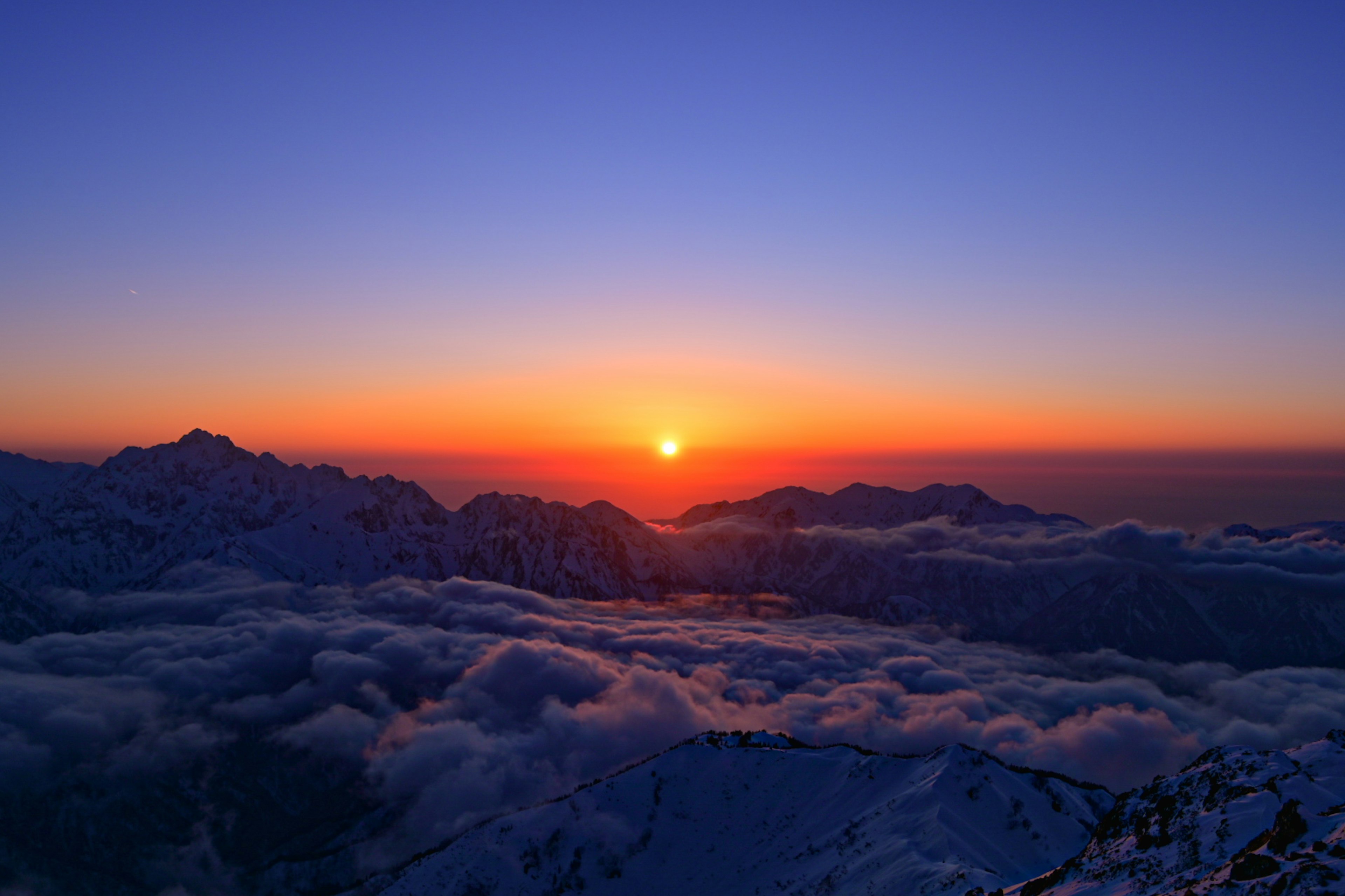 Vista panoramica del sole che sorge su montagne e nuvole