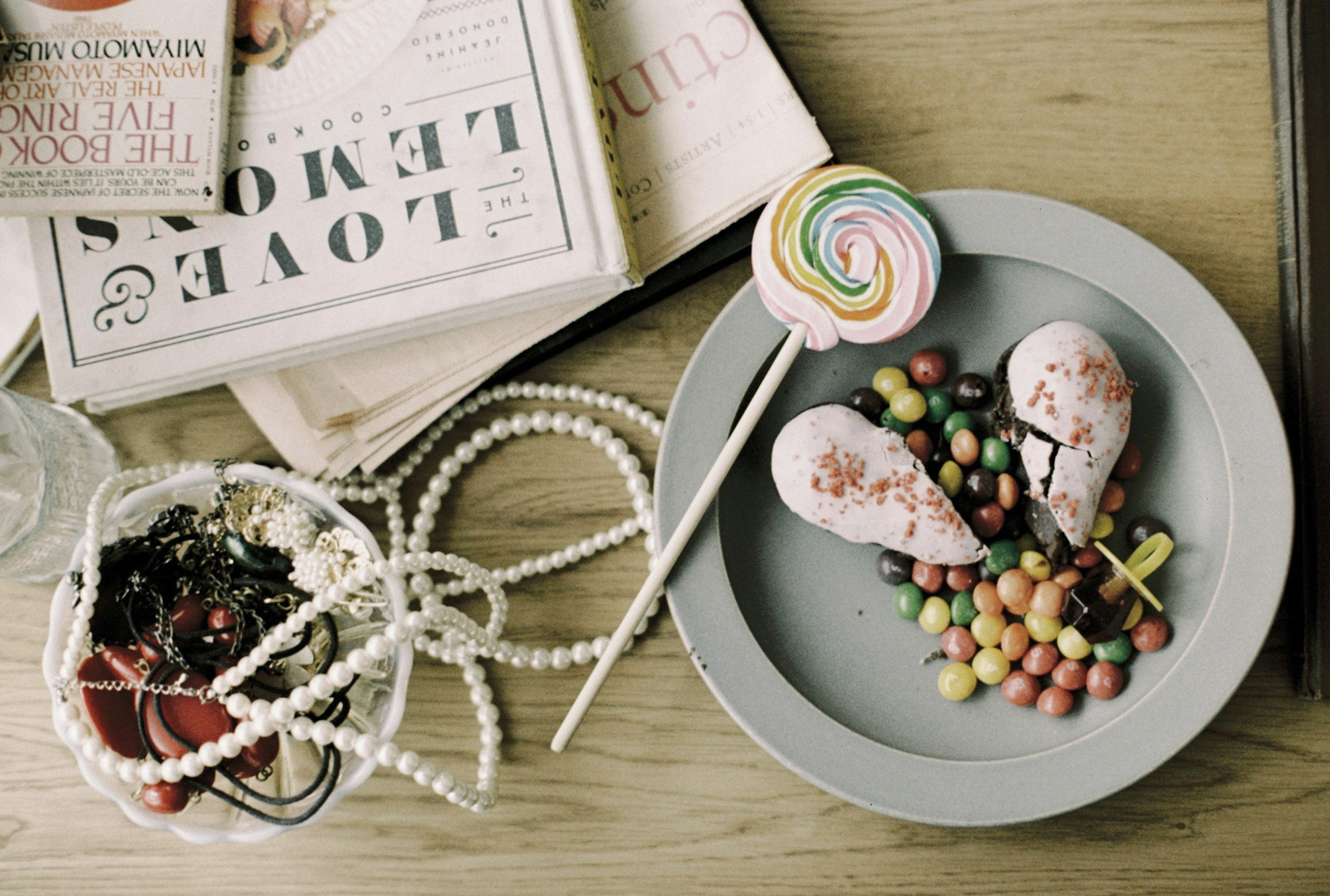 Dulces coloridos y helado dispuestos en un plato con revistas al fondo