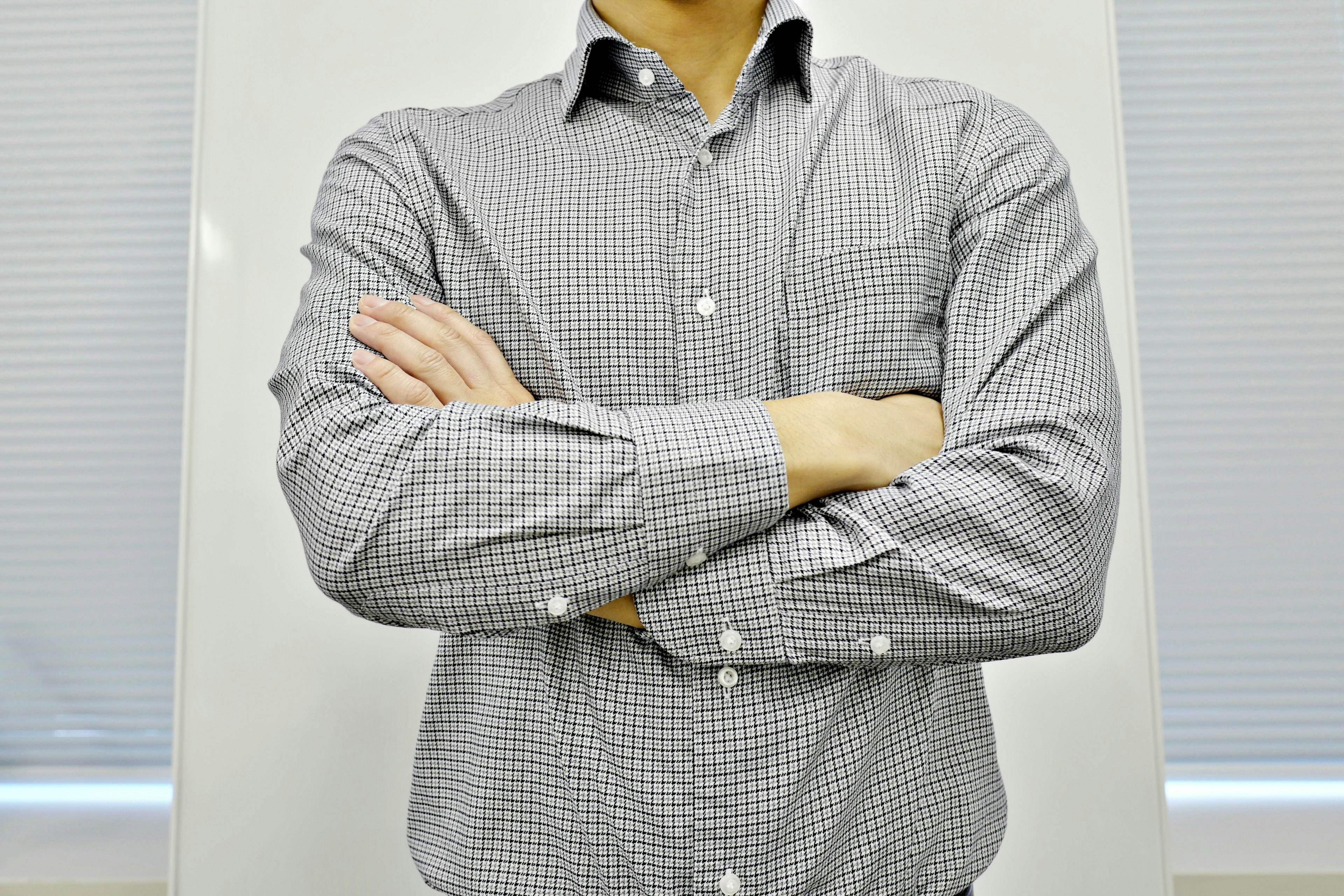 Hombre con camisa a cuadros de brazos cruzados