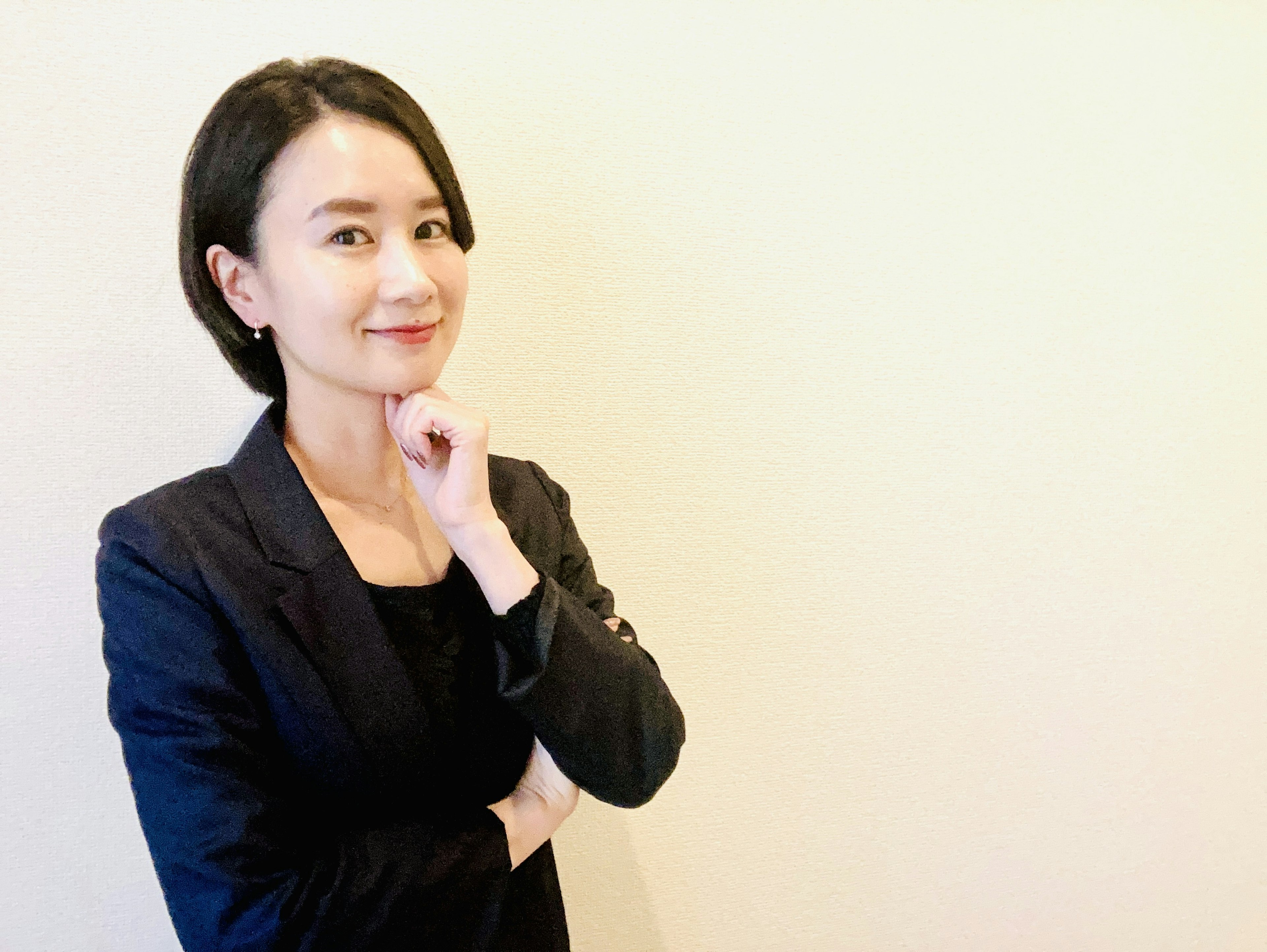 Woman in business suit with hand on chin thinking