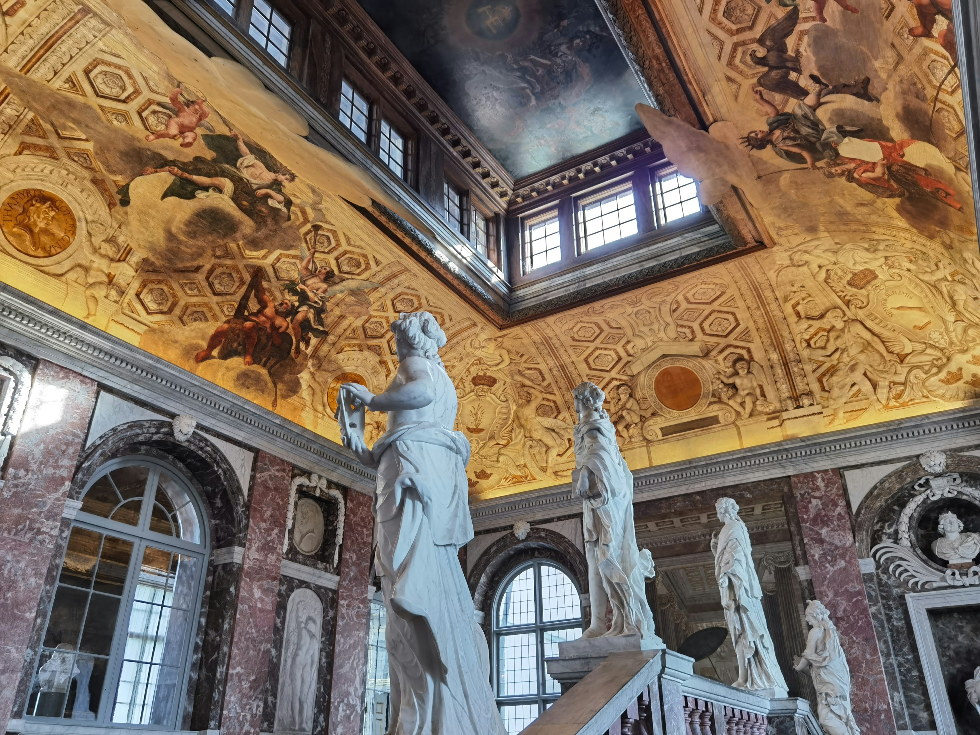 Elegant interior featuring ornate ceiling frescoes and marble statues