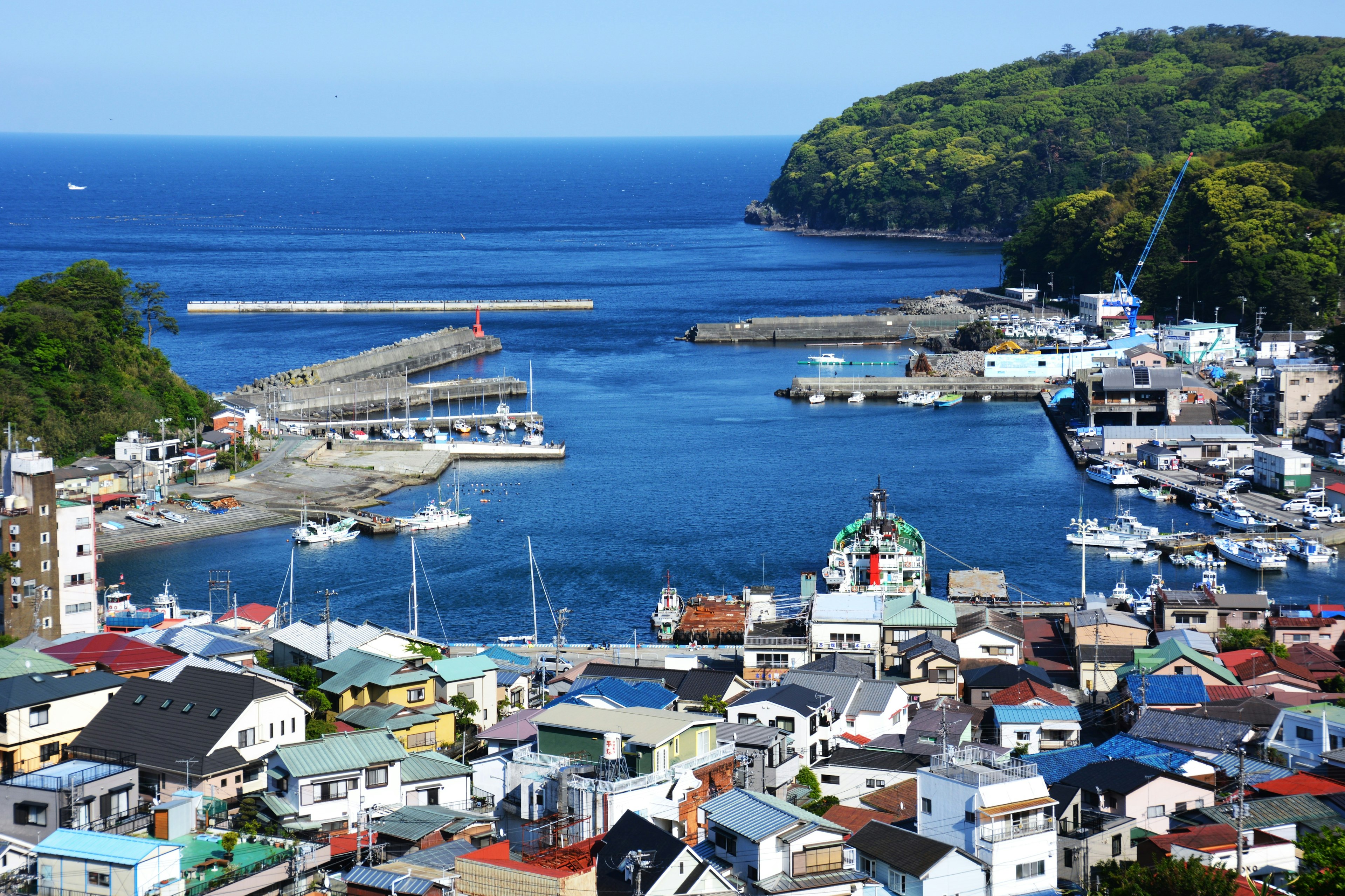 Bunte Häuser in einer Küstenstadt mit malerischem Hafen und blauem Meer