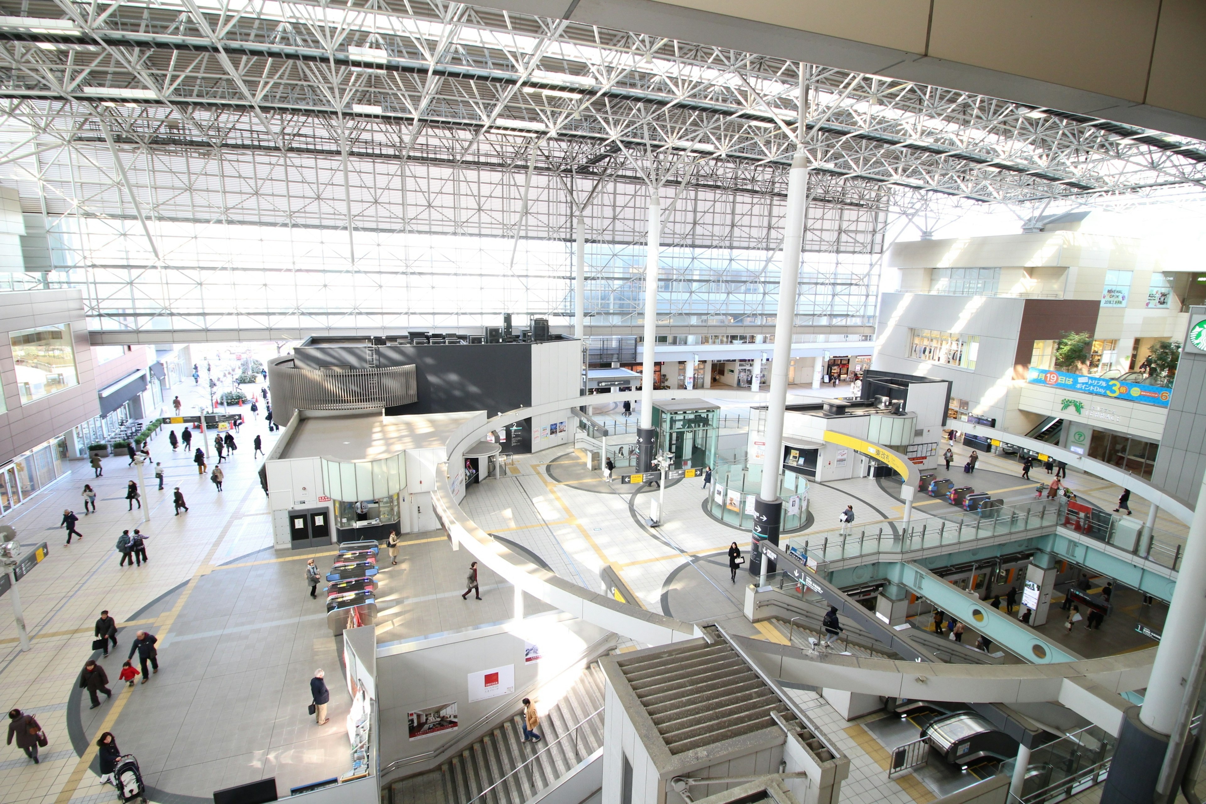 넓은 공항 내부 많은 사람들이 이동하고 밝은 자연광이 들어옴