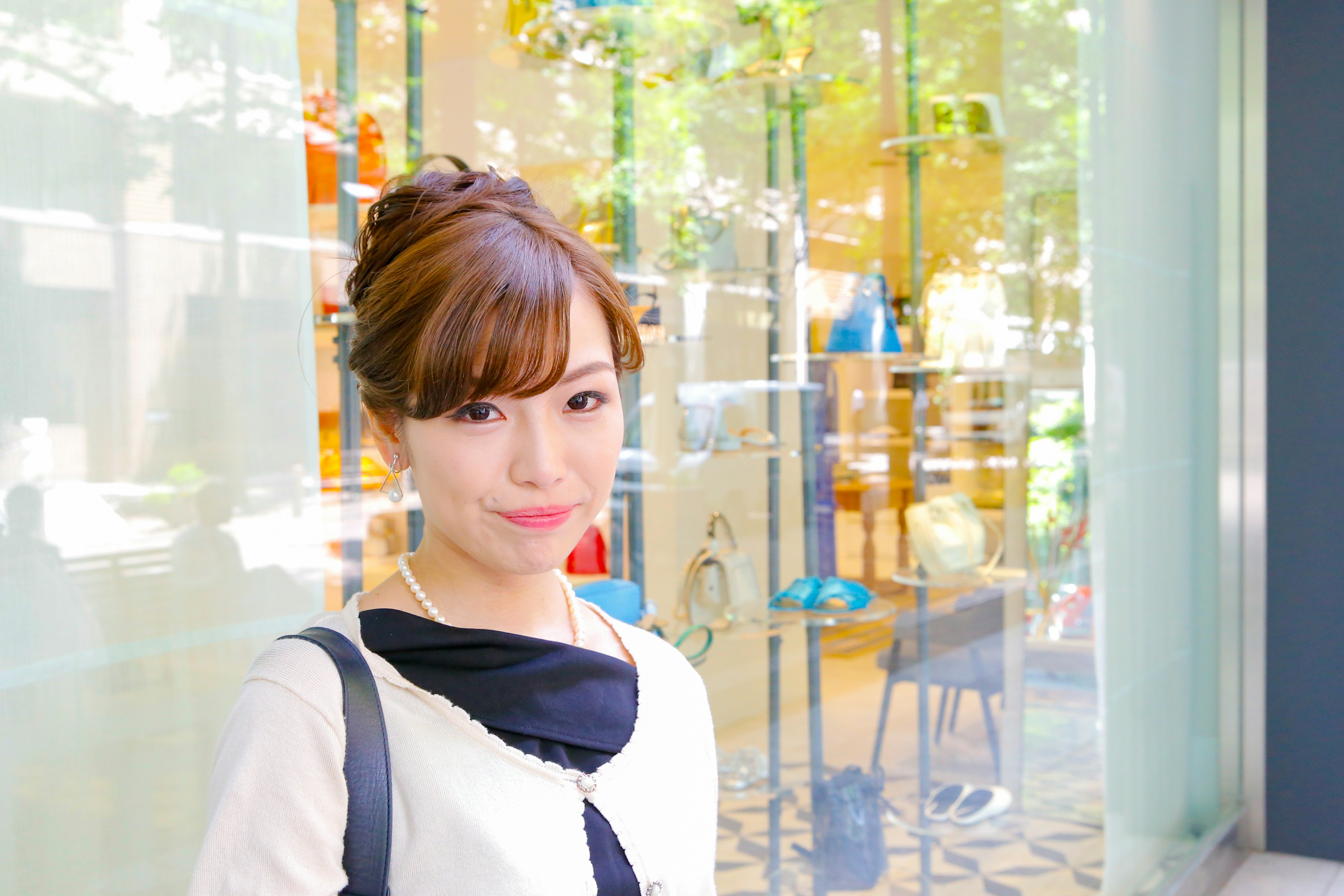 Portrait of a woman standing in front of a window with colorful decor items visible in the background