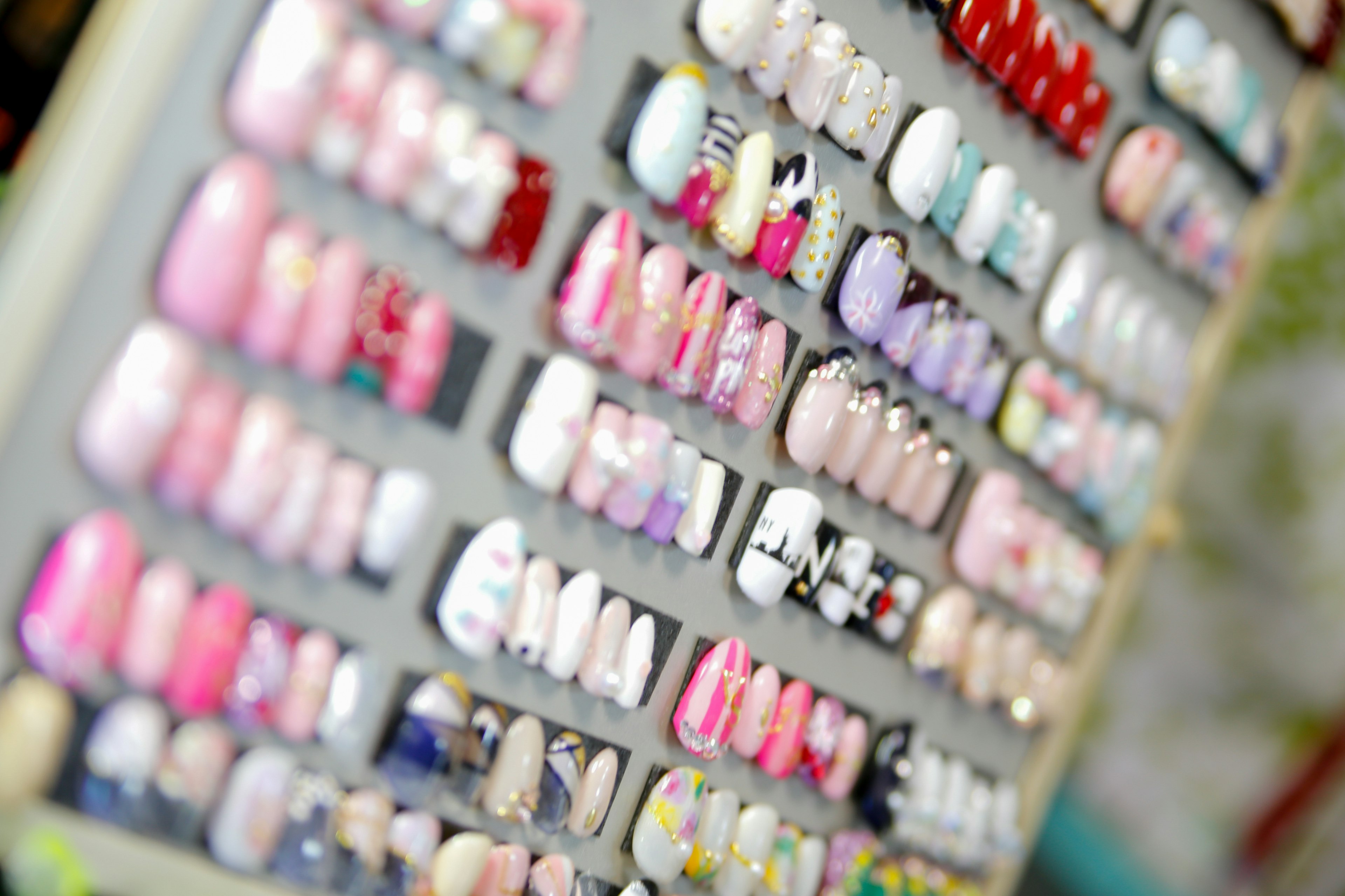 Image montrant une variété de faux ongles disposés en différents designs