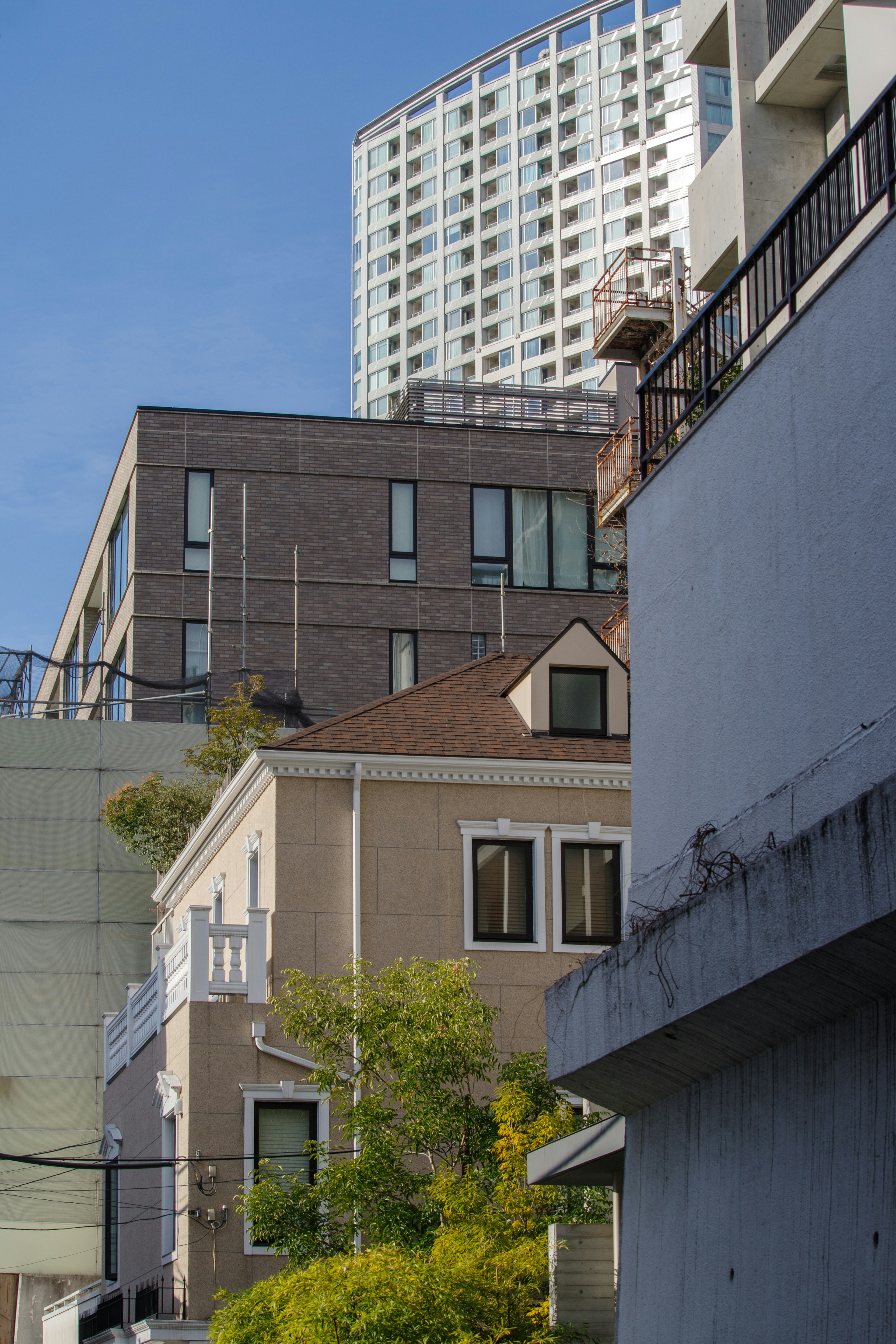 Urban landscape featuring a modern high-rise building and traditional houses