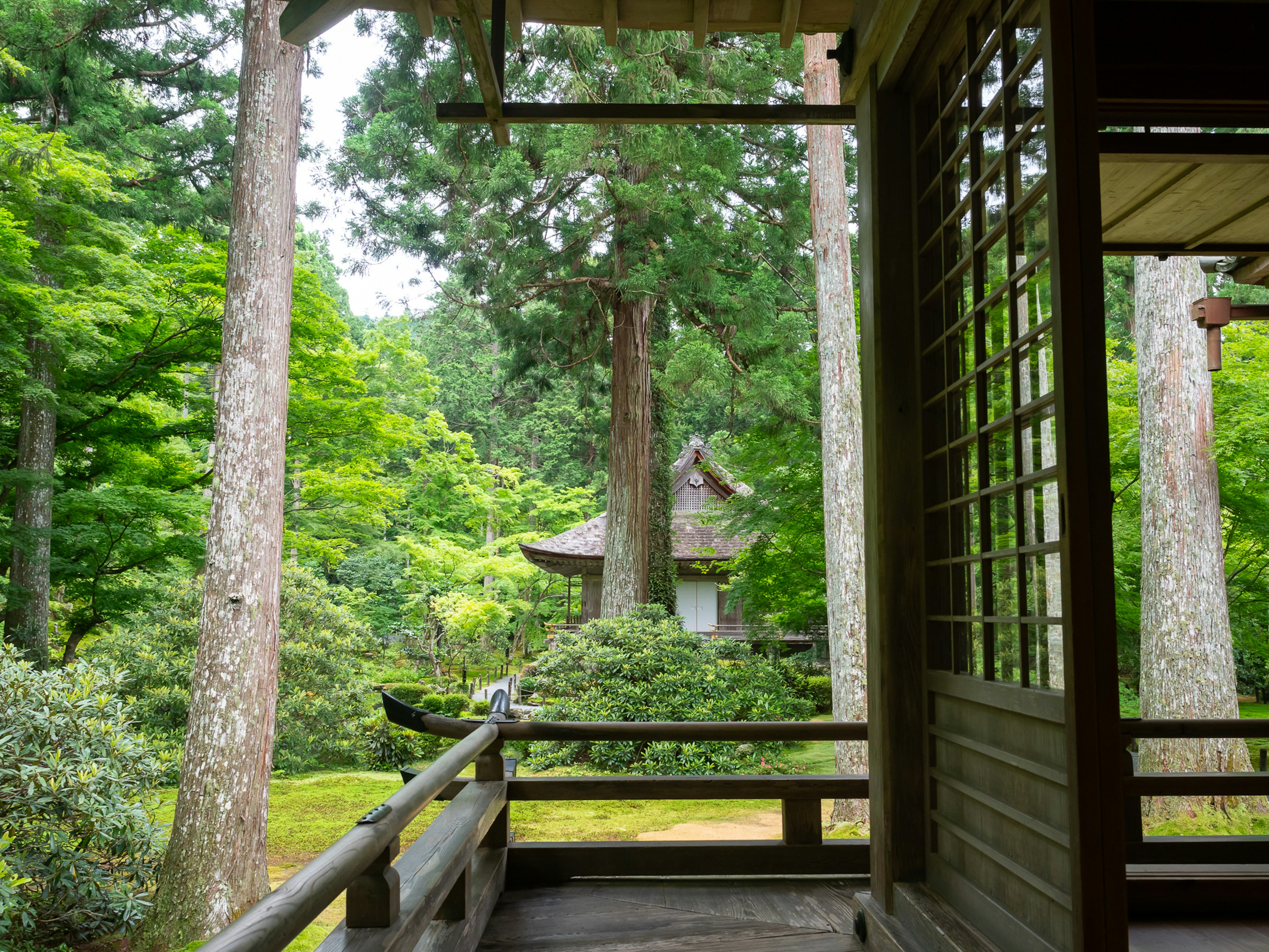 Terraza de un edificio tradicional japonés con vistas a un jardín exuberante