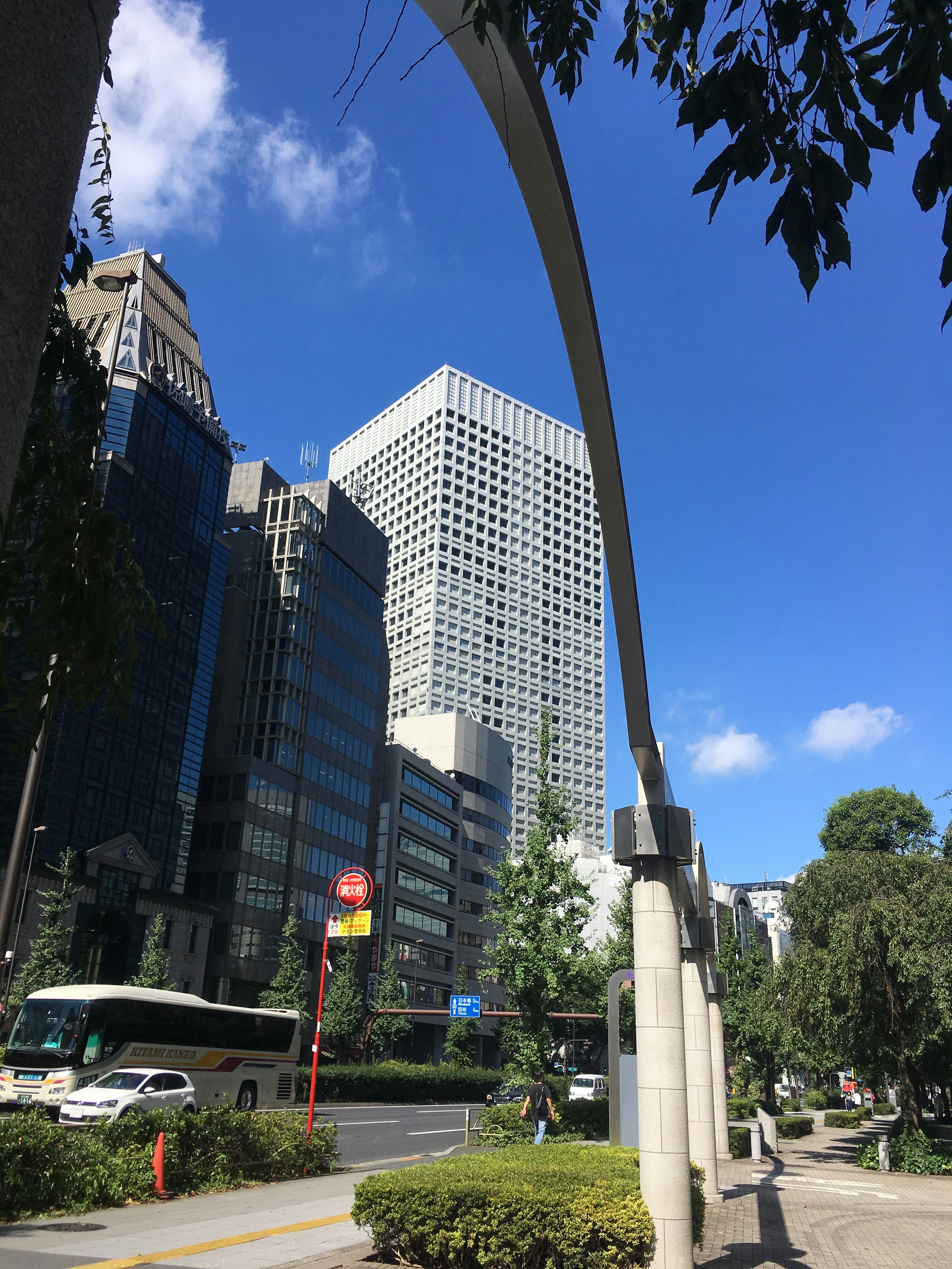 高層ビルと青空の風景にアーチ型の構造物がある