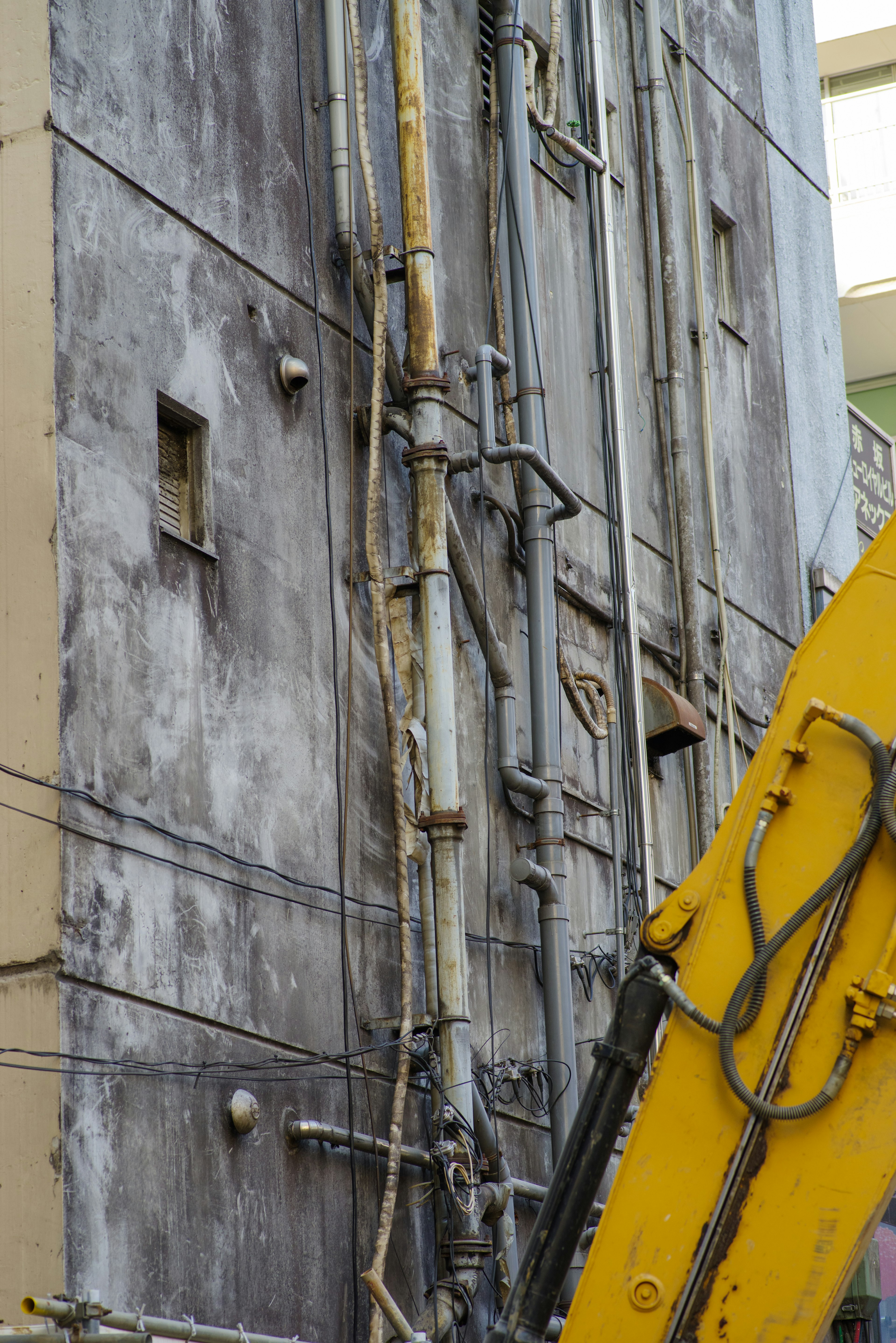 Detailed view of pipes and electrical wires on an old building's exterior