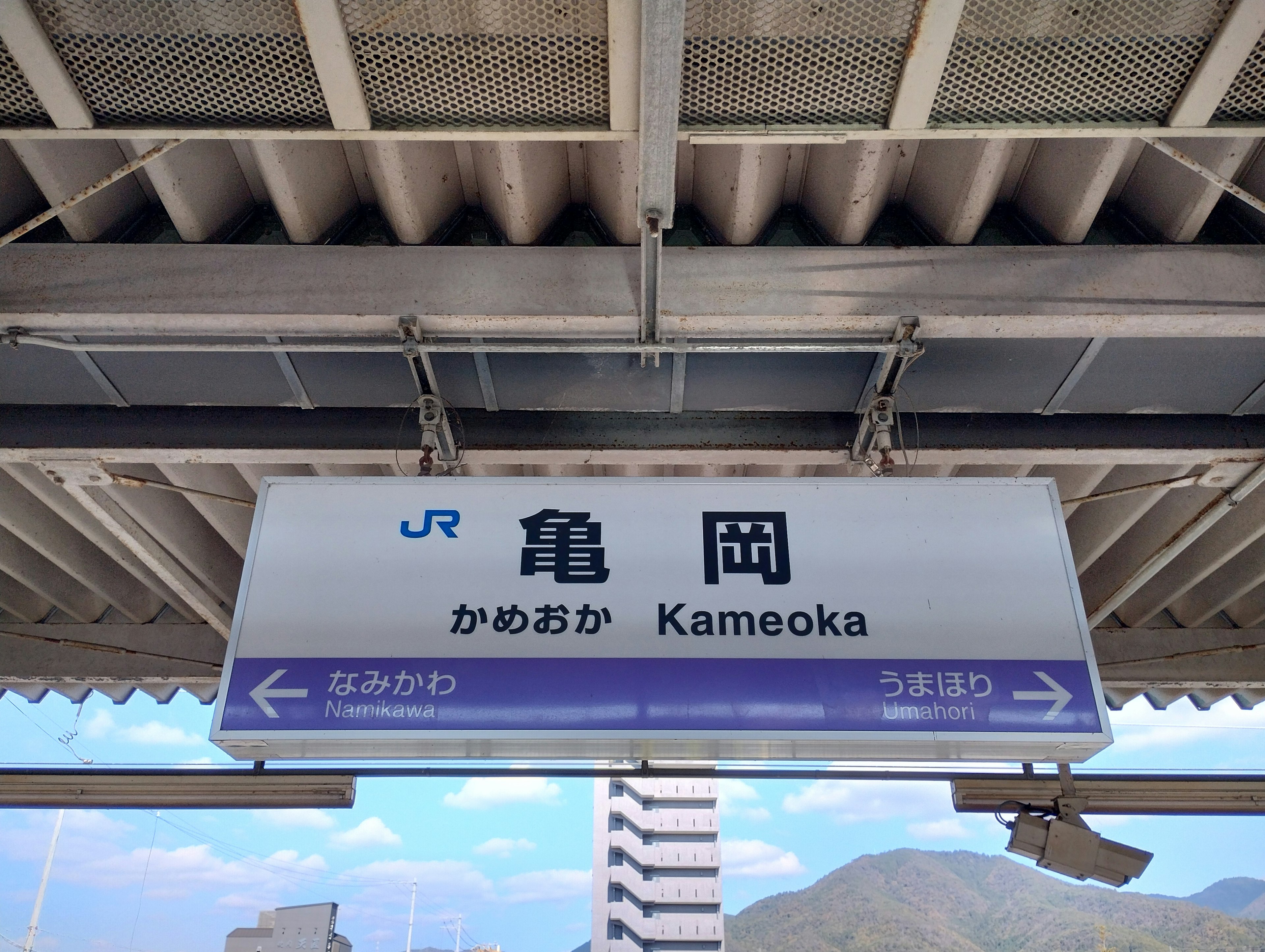 Sign for Kameoka Station showing Japanese and romaji text