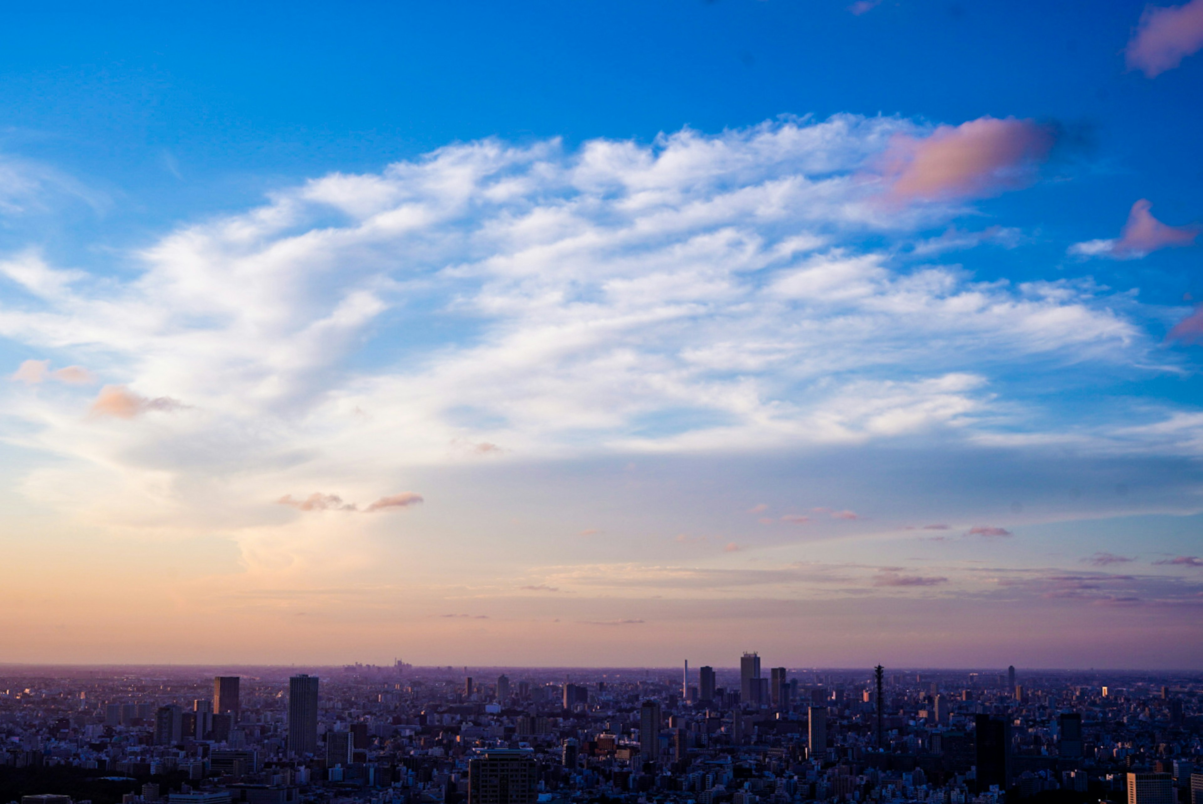 東京天際線與夕陽下的生動雲彩