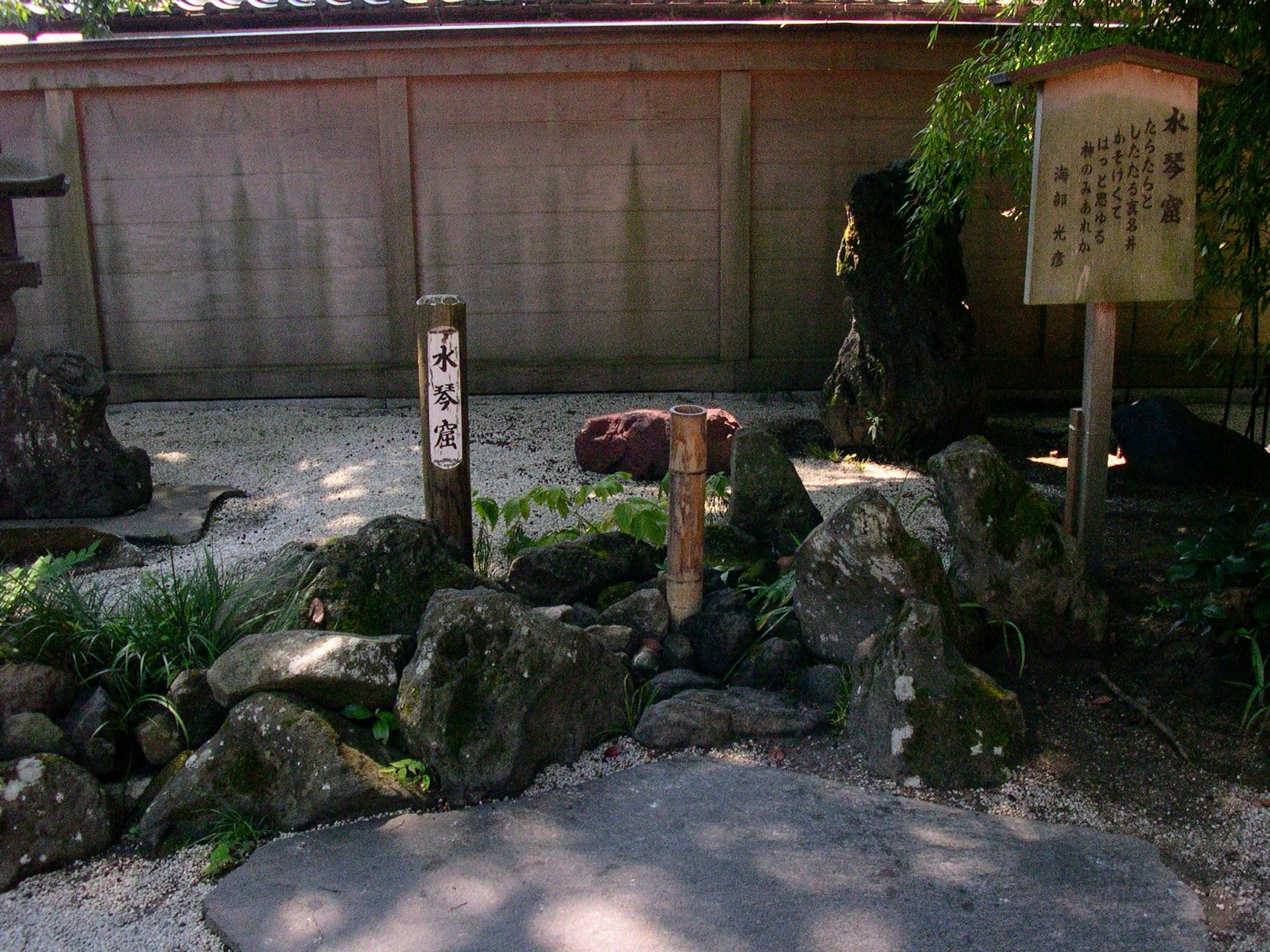 寧靜的日本花園入口，石頭與綠色植物相映成趣