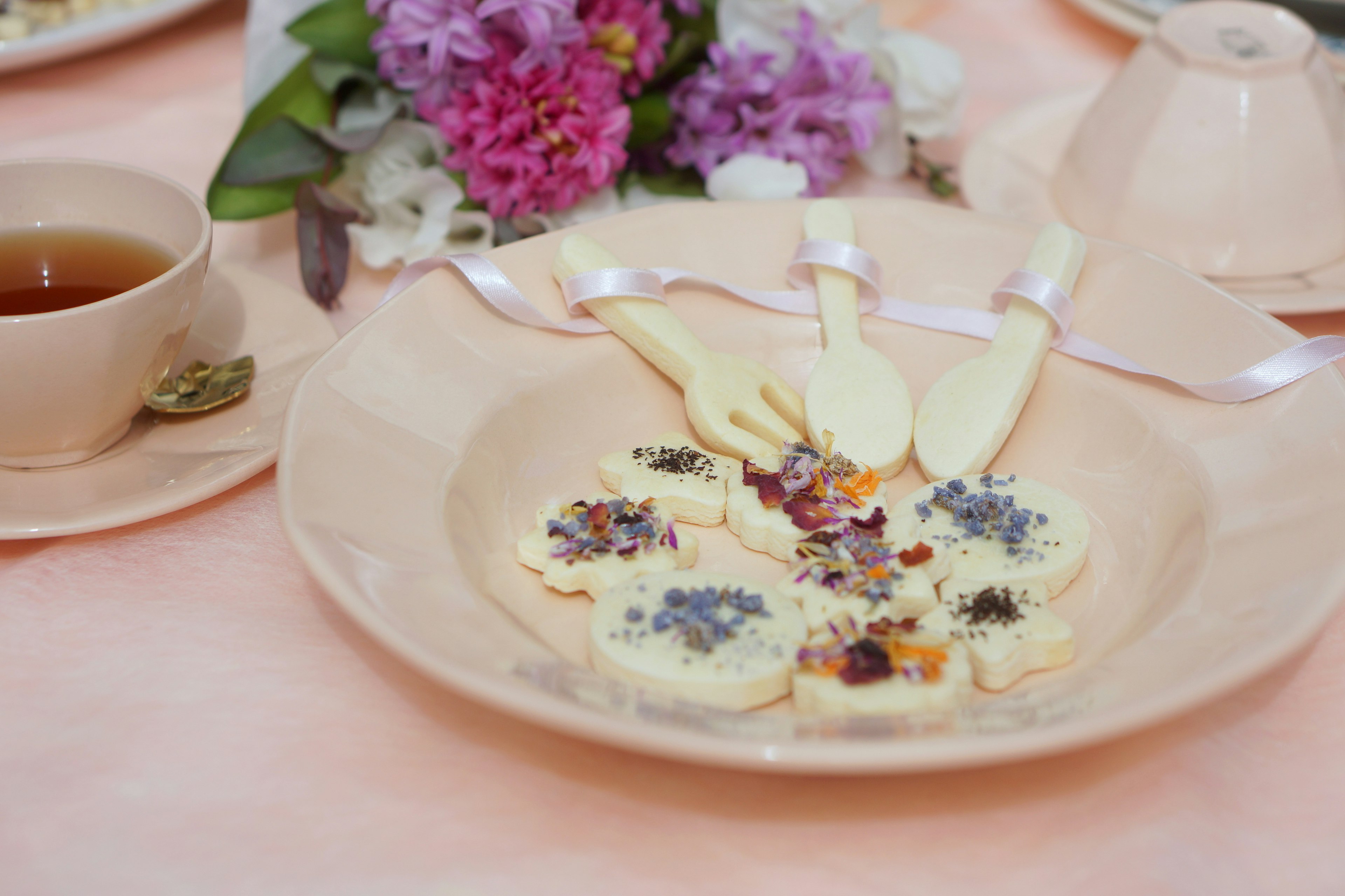 Plato de postre con decoración floral y taza de té