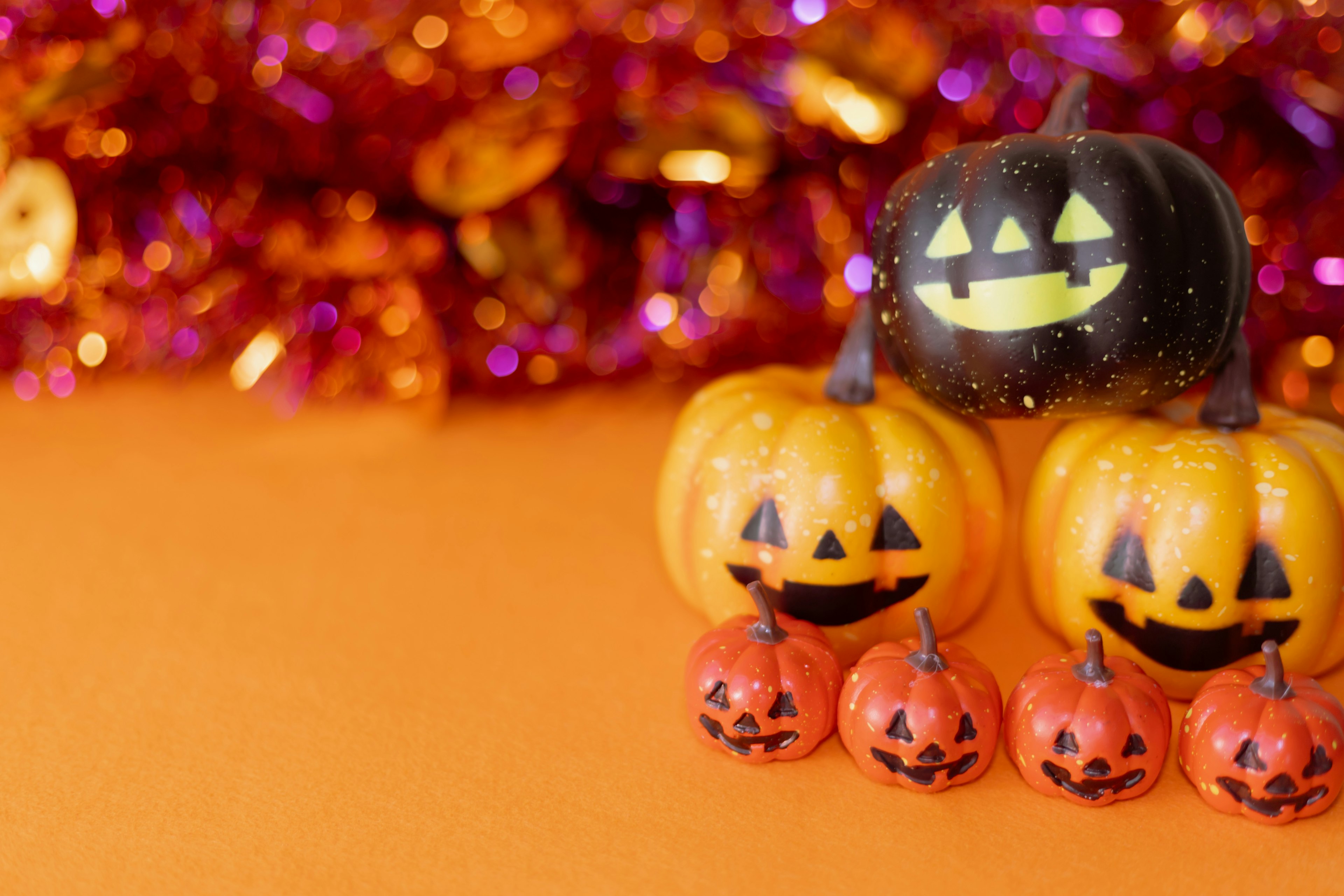 Calabazas de Halloween coloridas dispuestas sobre un fondo naranja