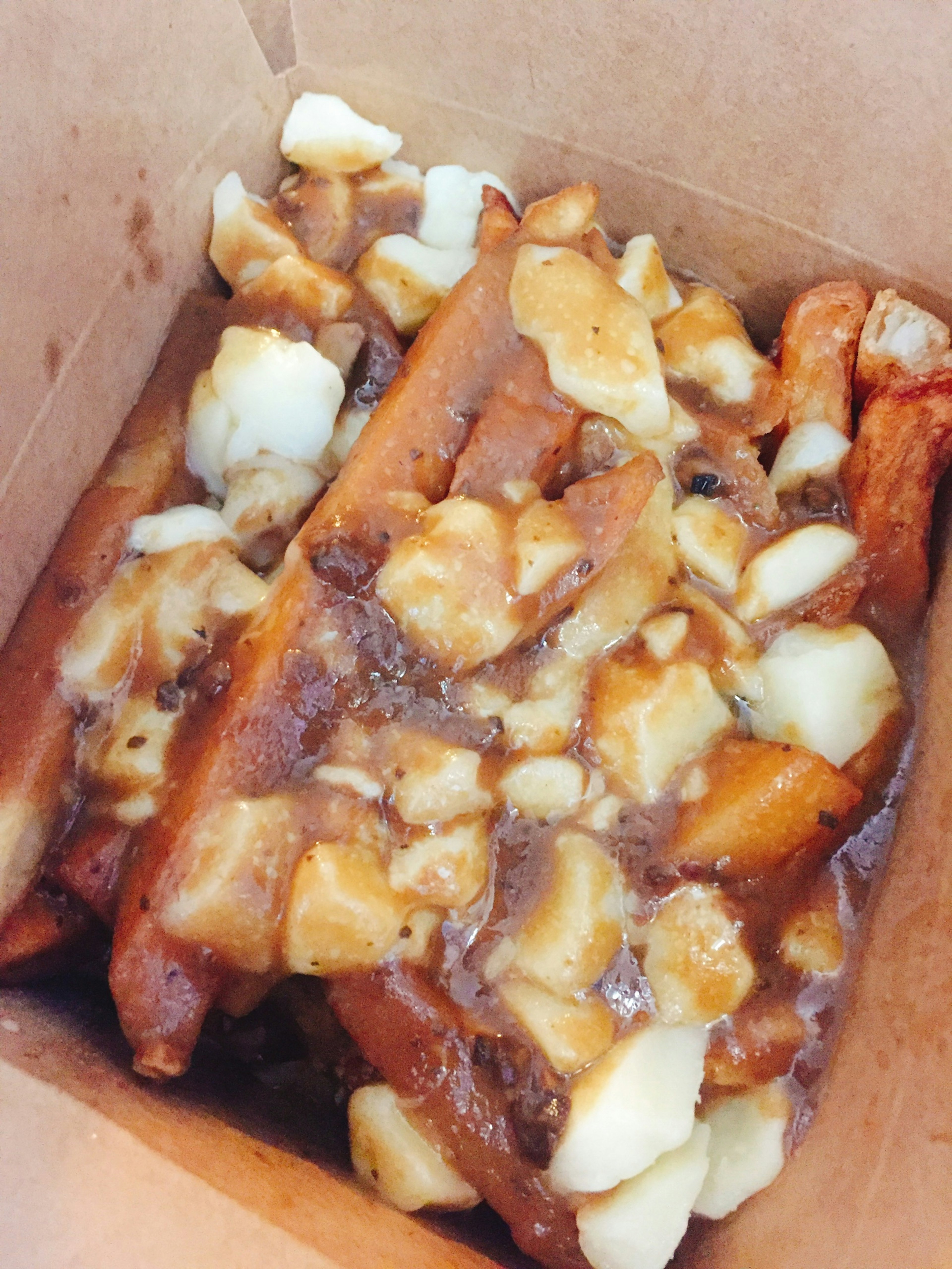 Poutine dengan kentang goreng yang dilapisi saus dan keju curd