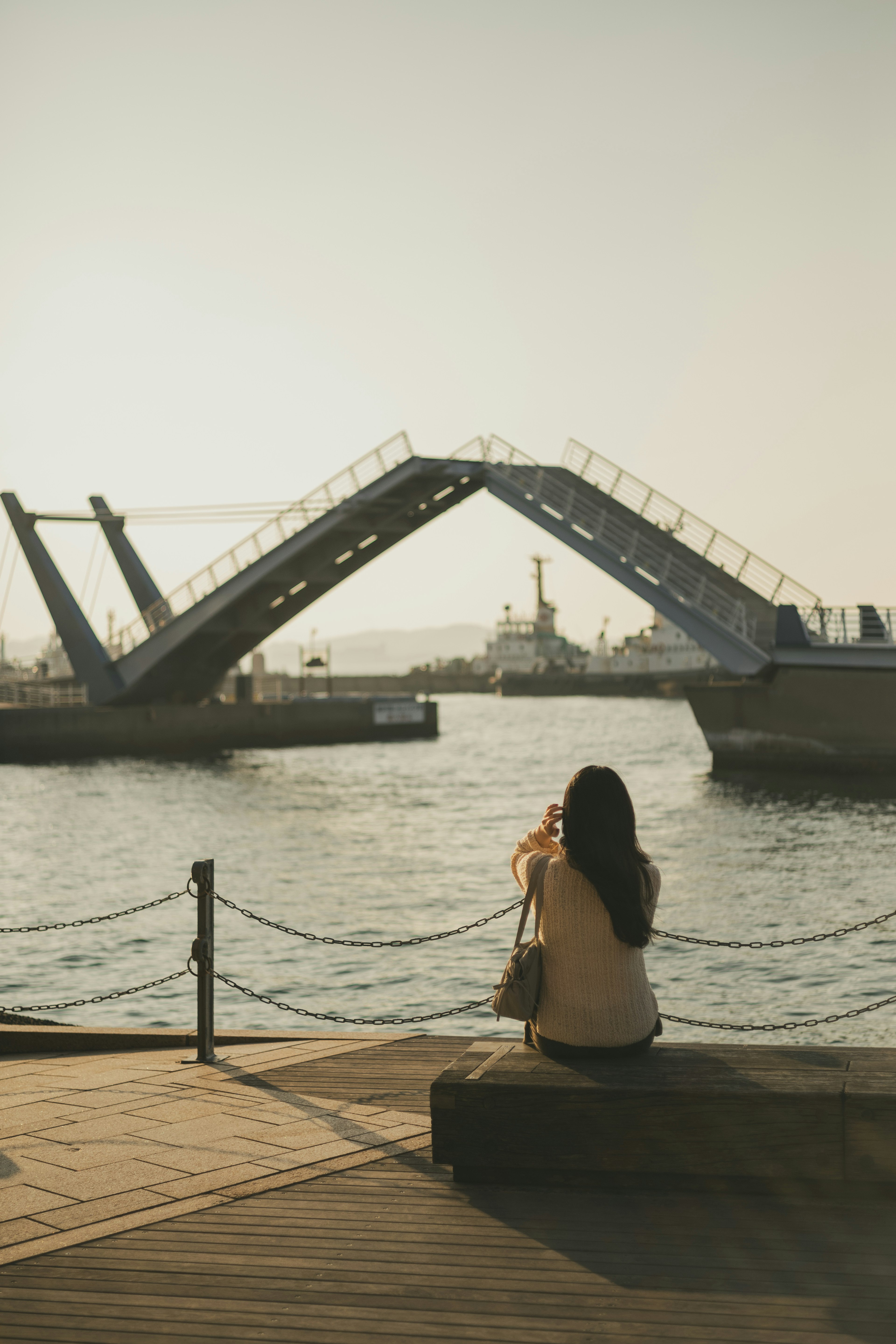 Eine Frau macht ein Foto mit einer Brücke im Hintergrund