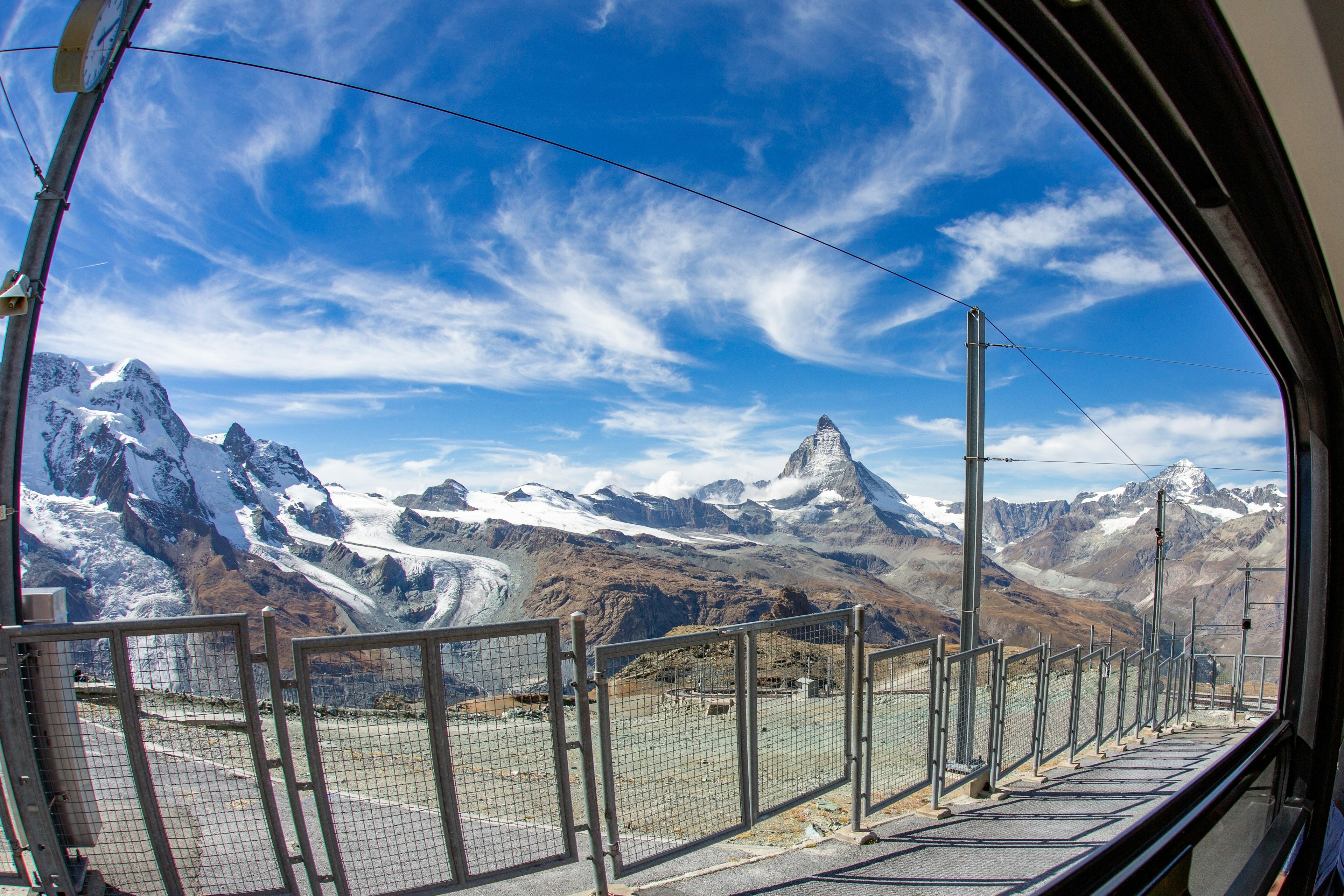 Panoramablick auf schneebedeckte Berge und blauen Himmel aus einem Fenster