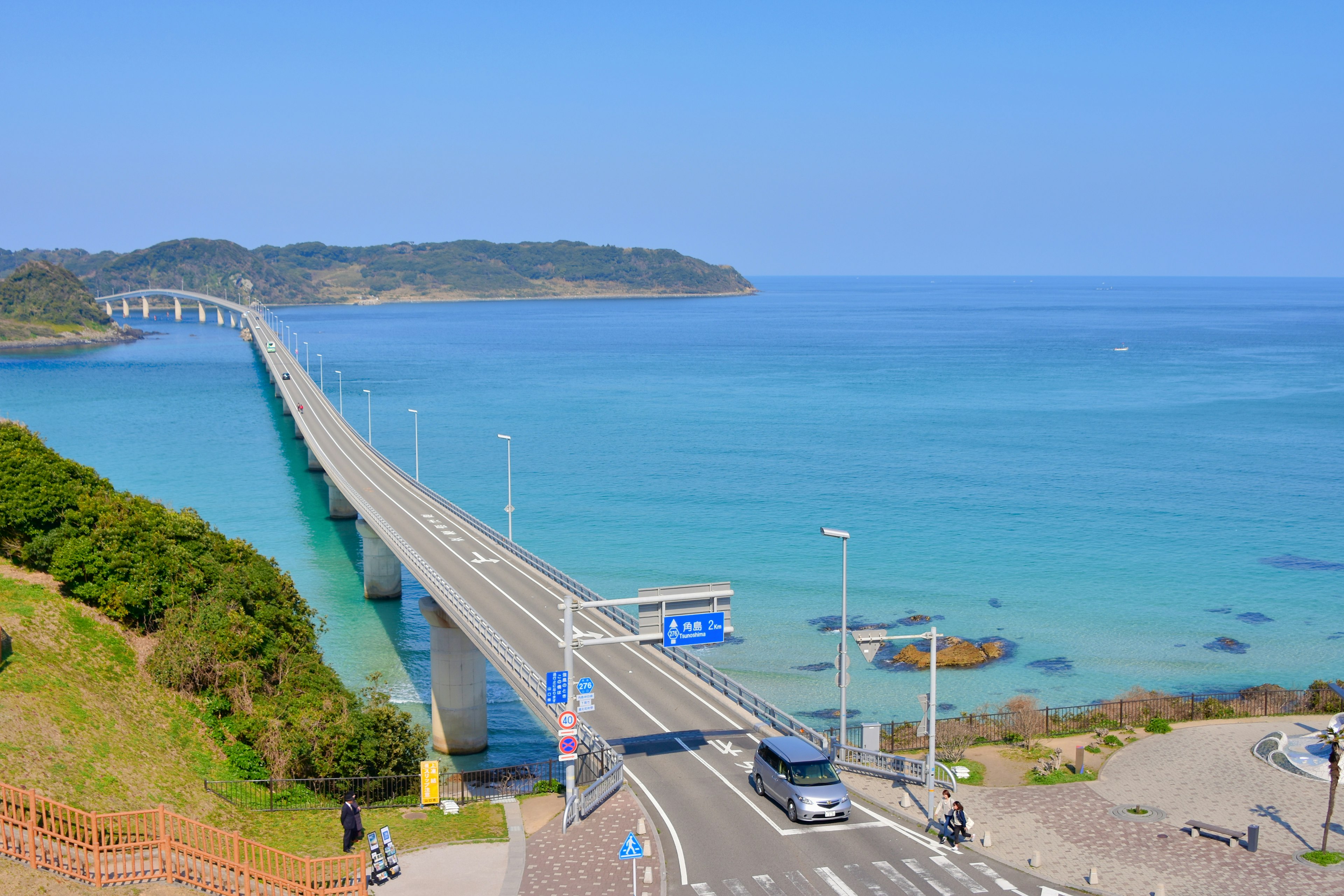 Vista escénica de un mar azul y un puente con coches en la carretera y paisaje natural