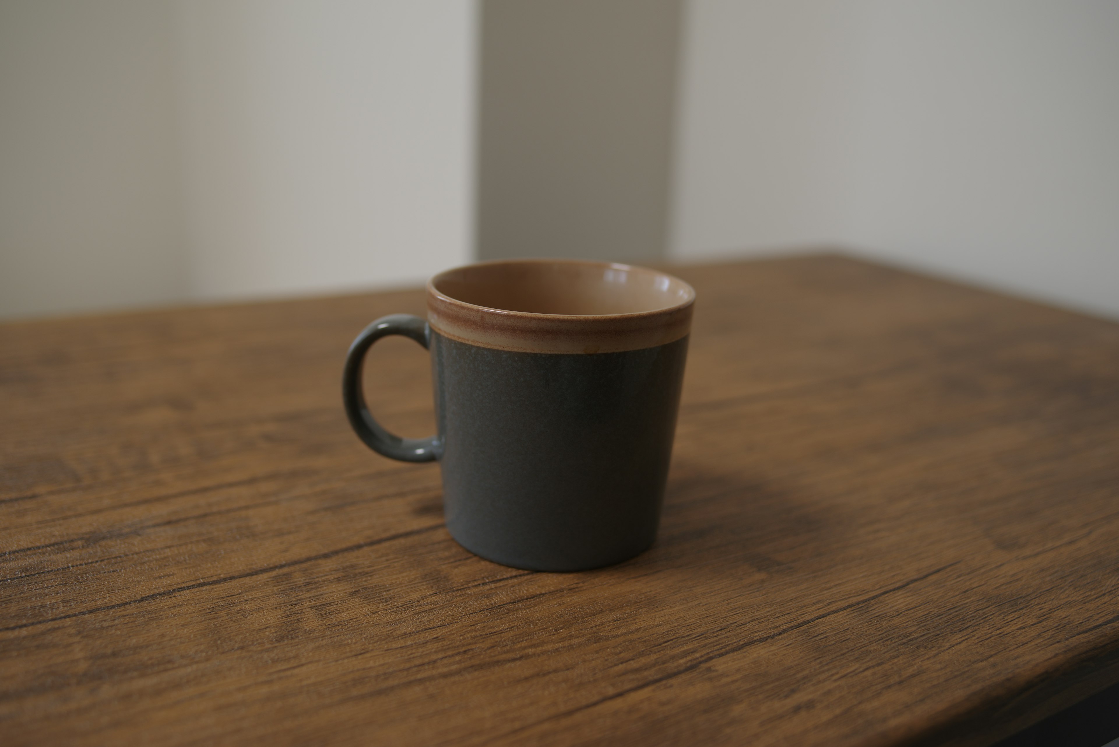 Taza negra colocada sobre una mesa de madera