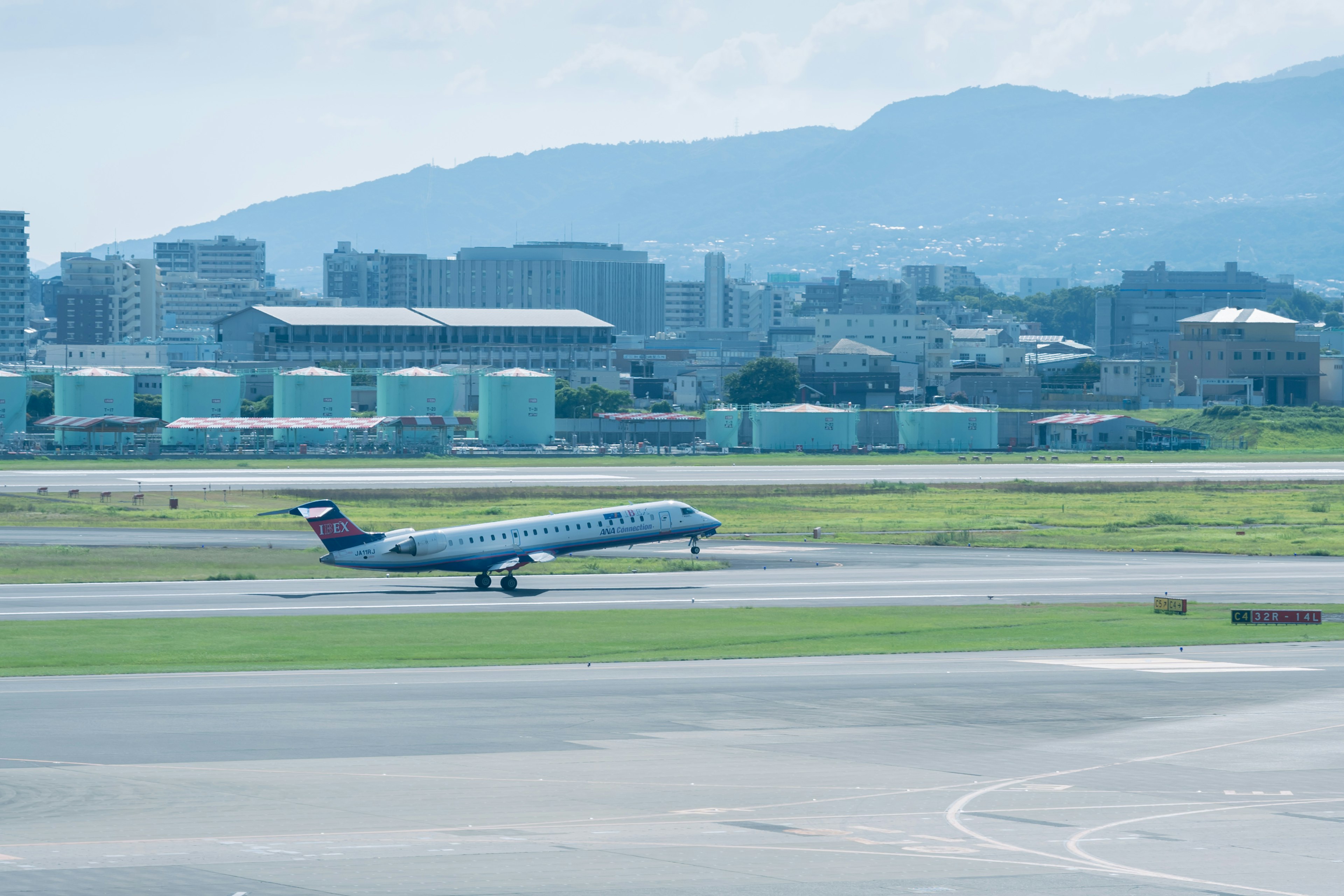 Aereo passeggeri in decollo all'aeroporto con montagne sullo sfondo