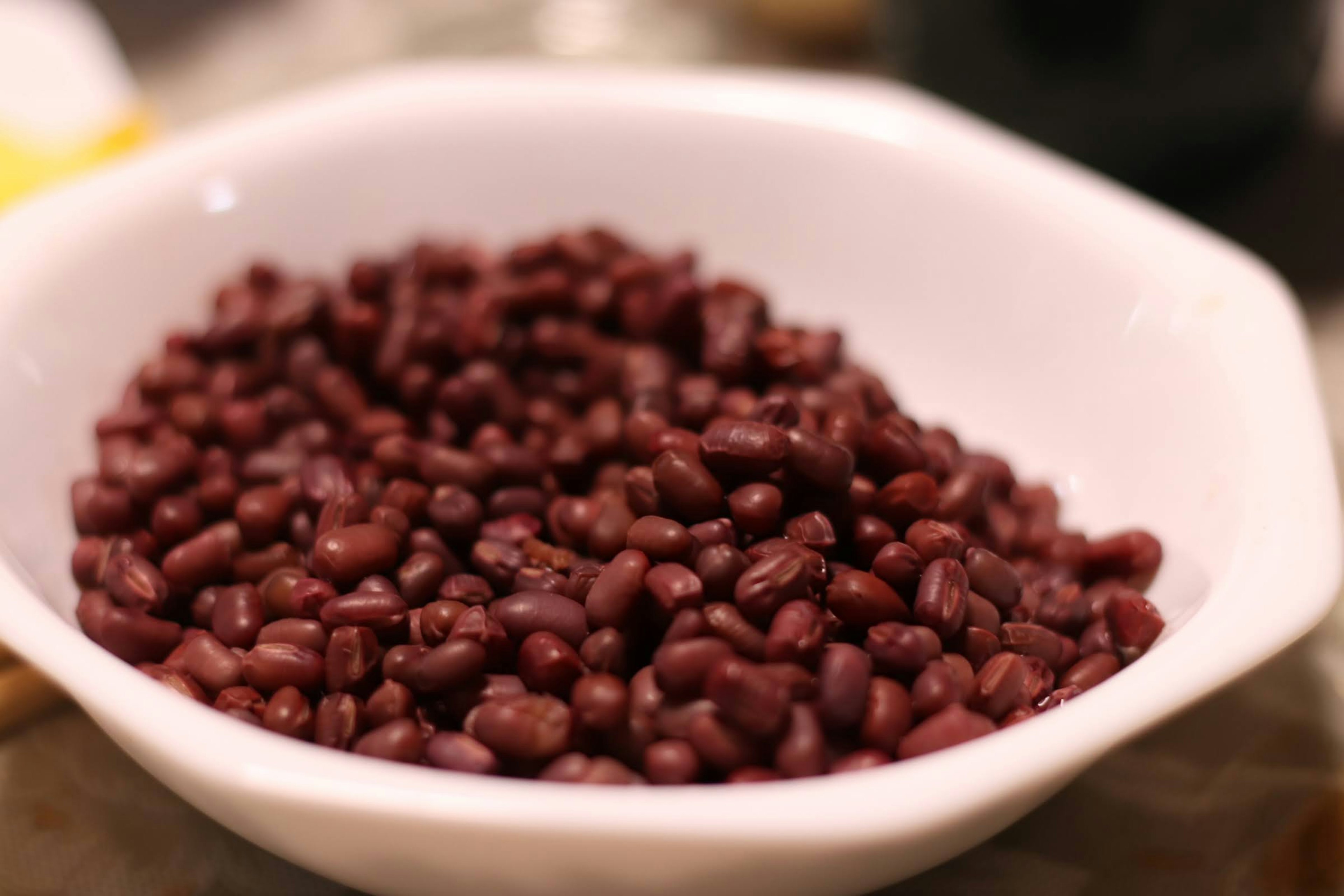 Un tazón de frijoles rojos en un plato blanco