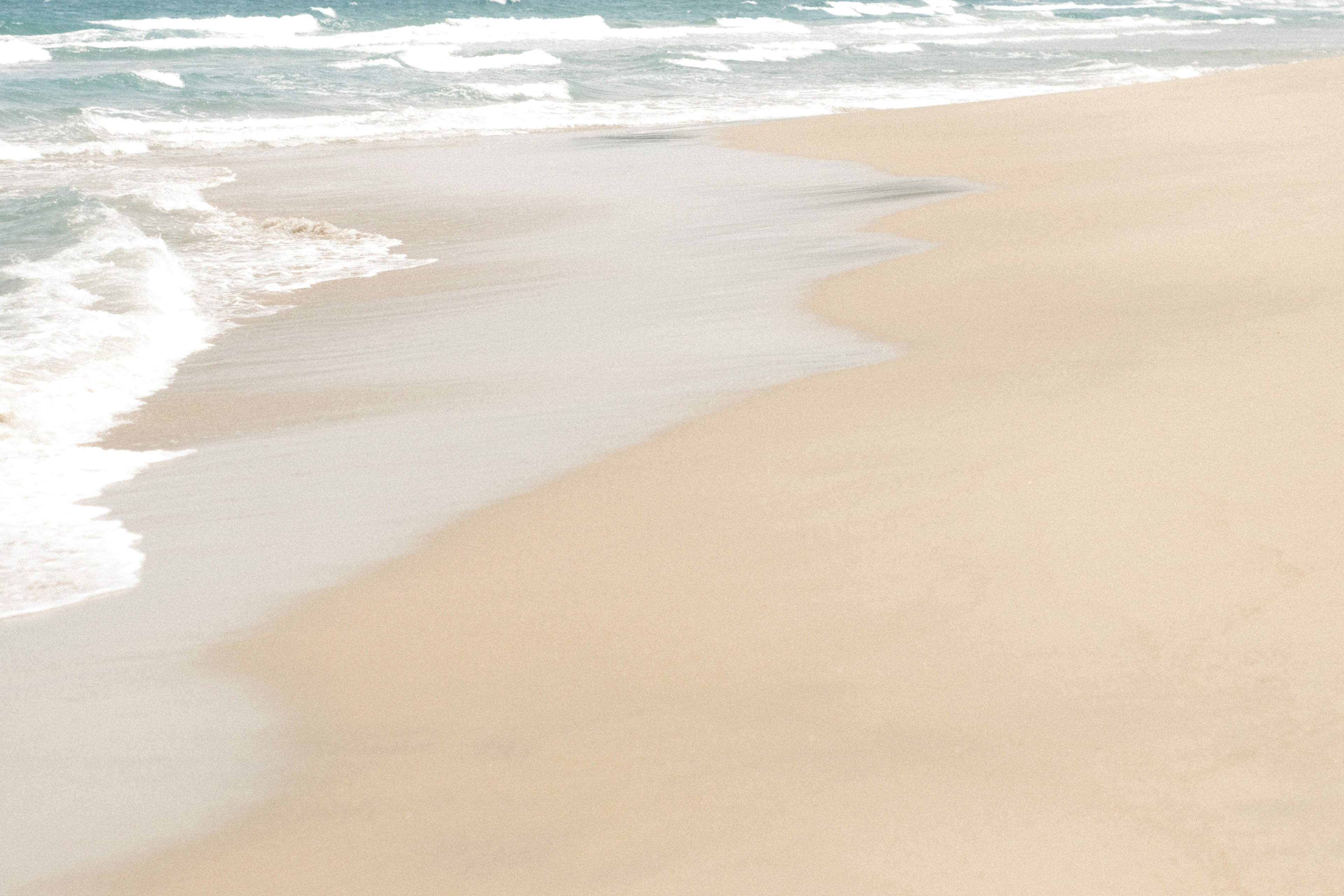 ทิวทัศน์ชายหาดที่เงียบสงบมีคลื่นอ่อนๆซัดเข้าหาทราย