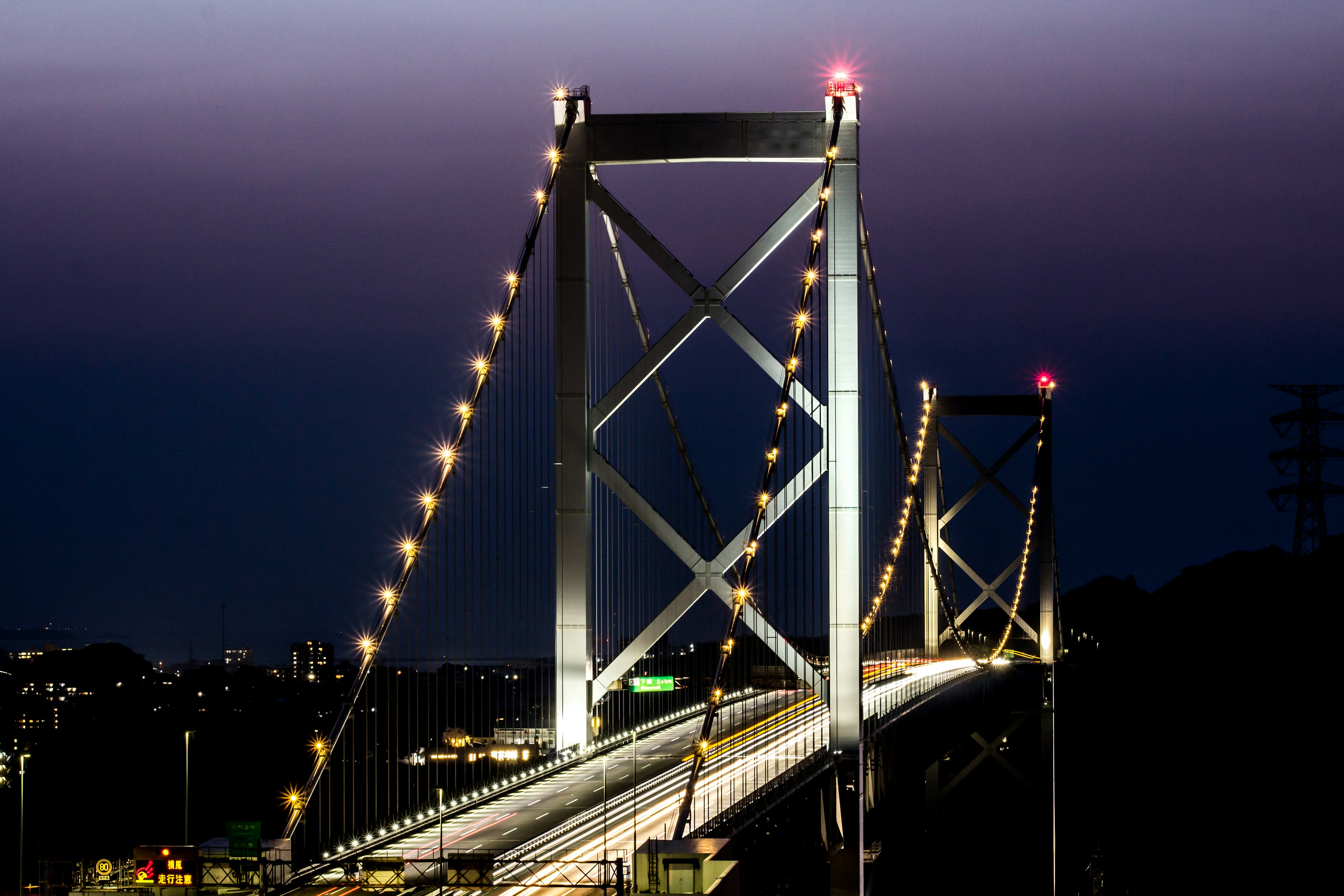 Puente colgante iluminado contra un cielo crepuscular