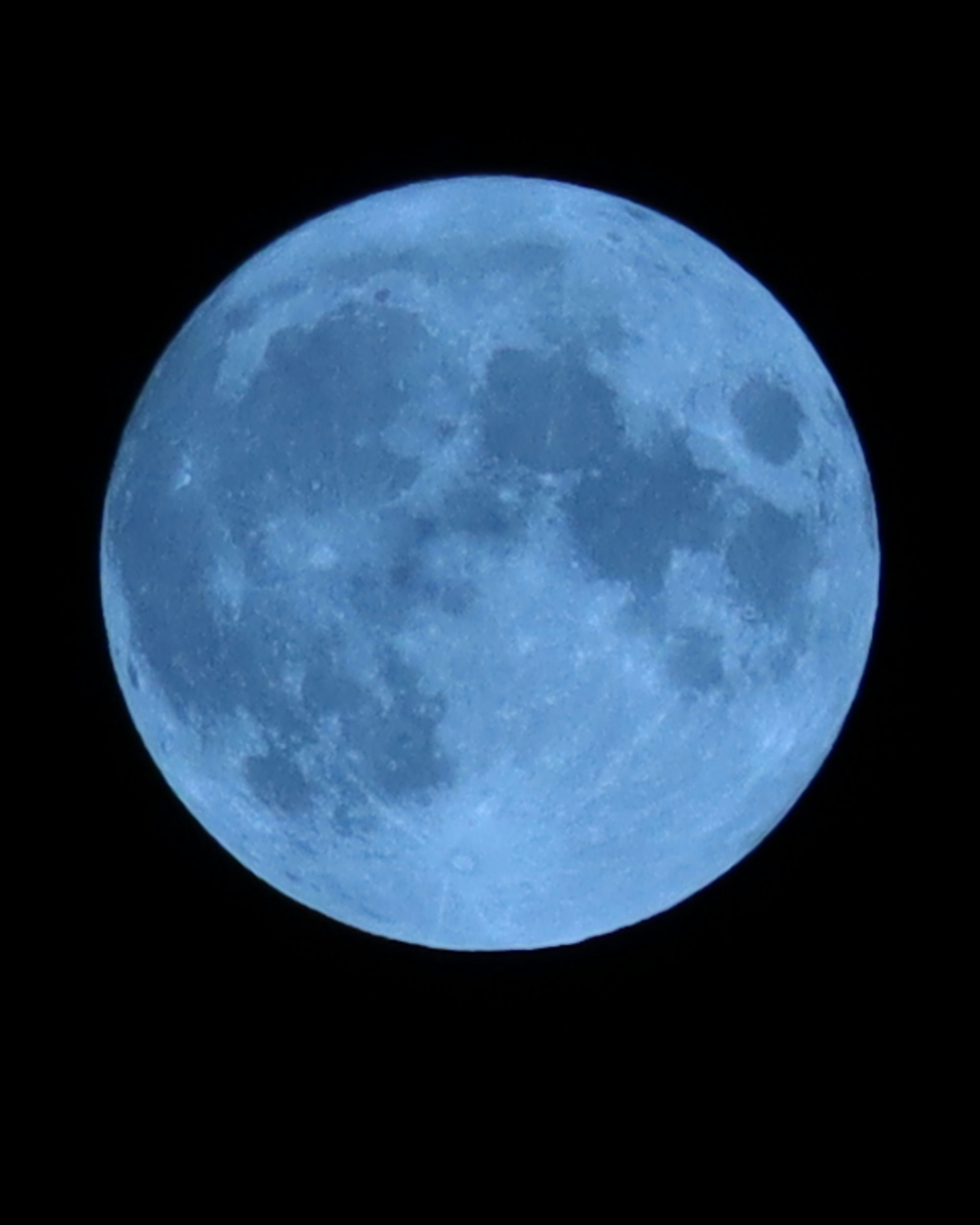 Detailed image of a blue moon floating against a dark background