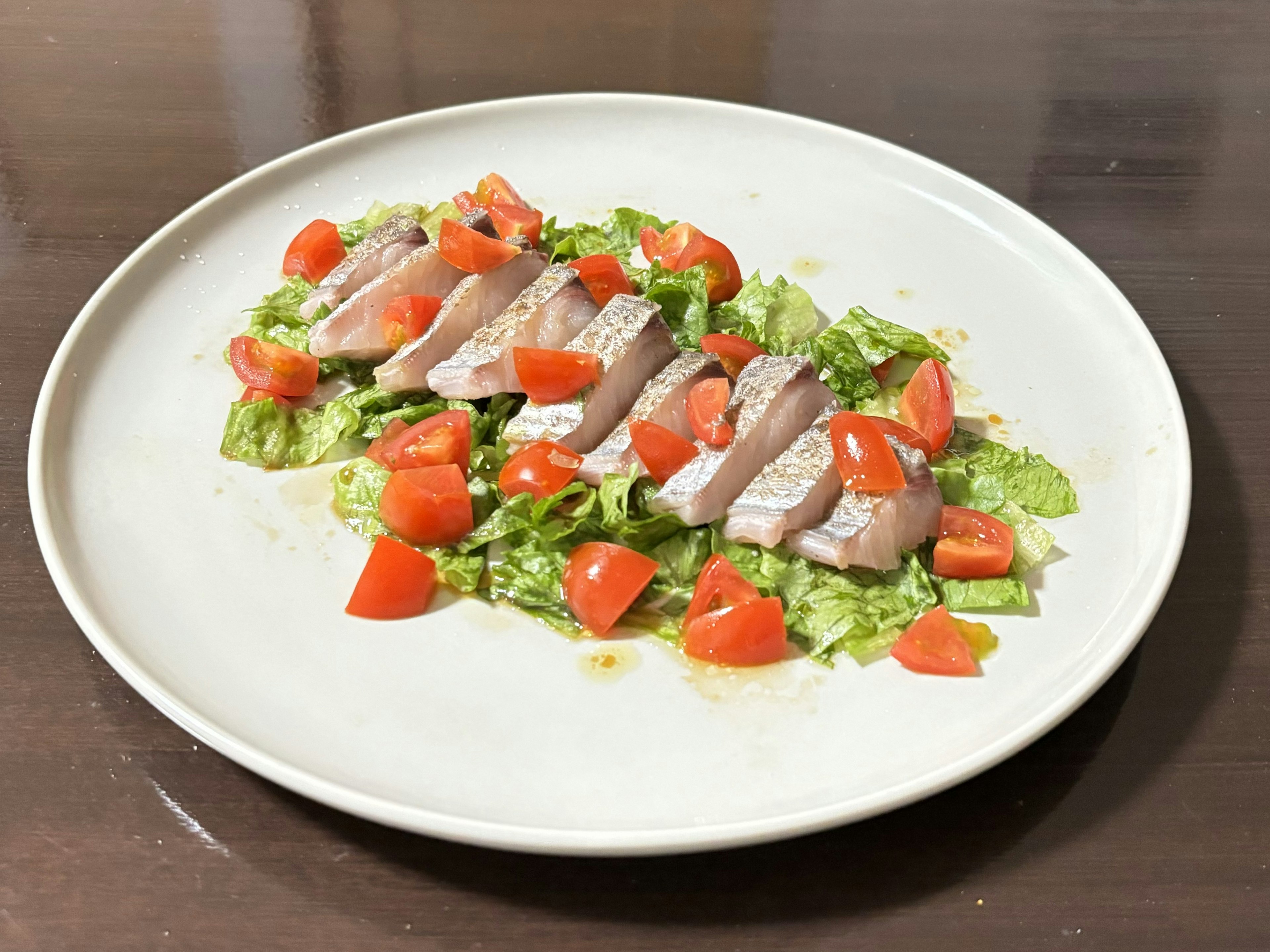 Pechuga de pollo en rodajas sobre una cama de lechuga con tomates picados