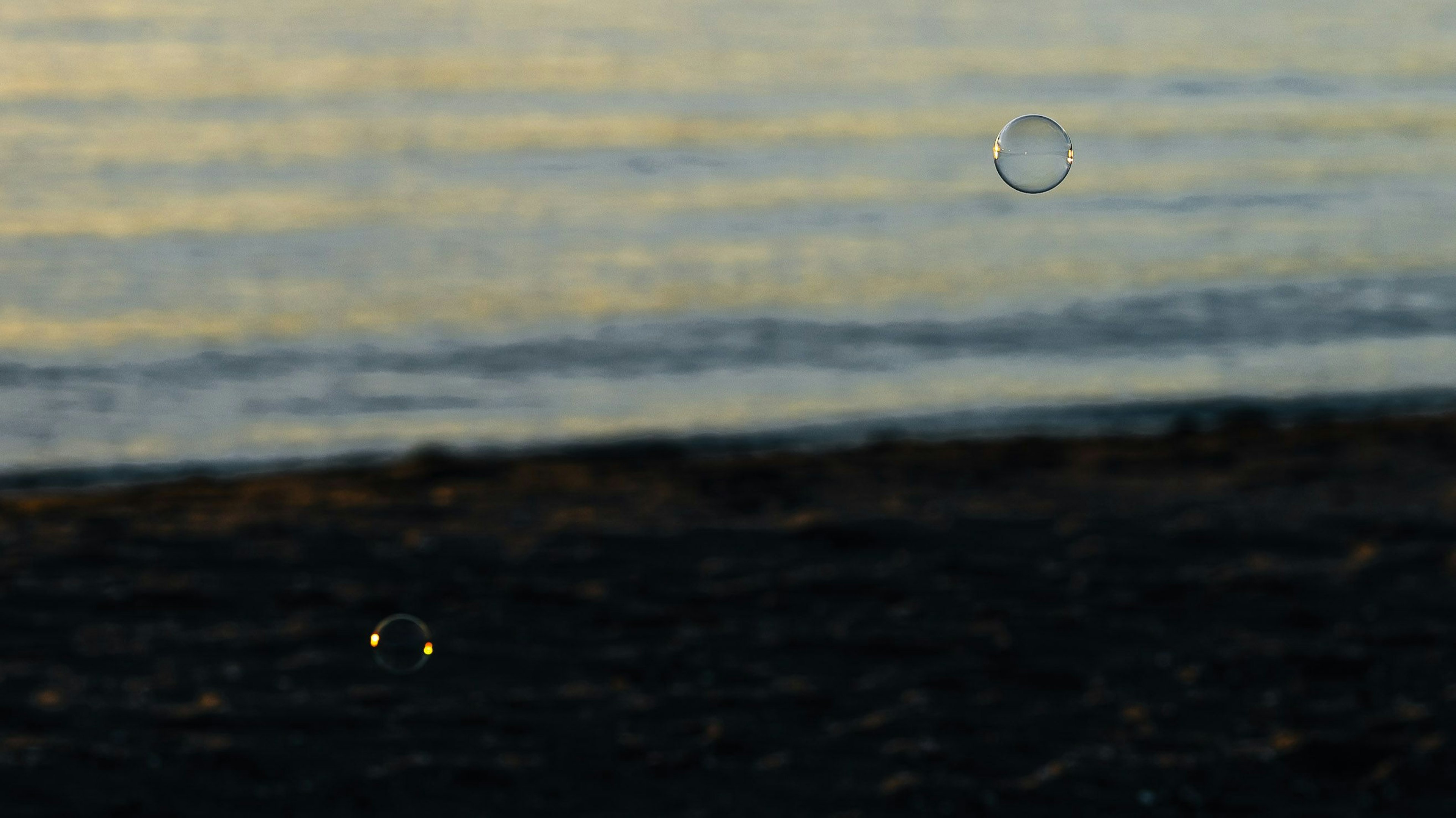 Burbujas flotando sobre una playa con olas suaves