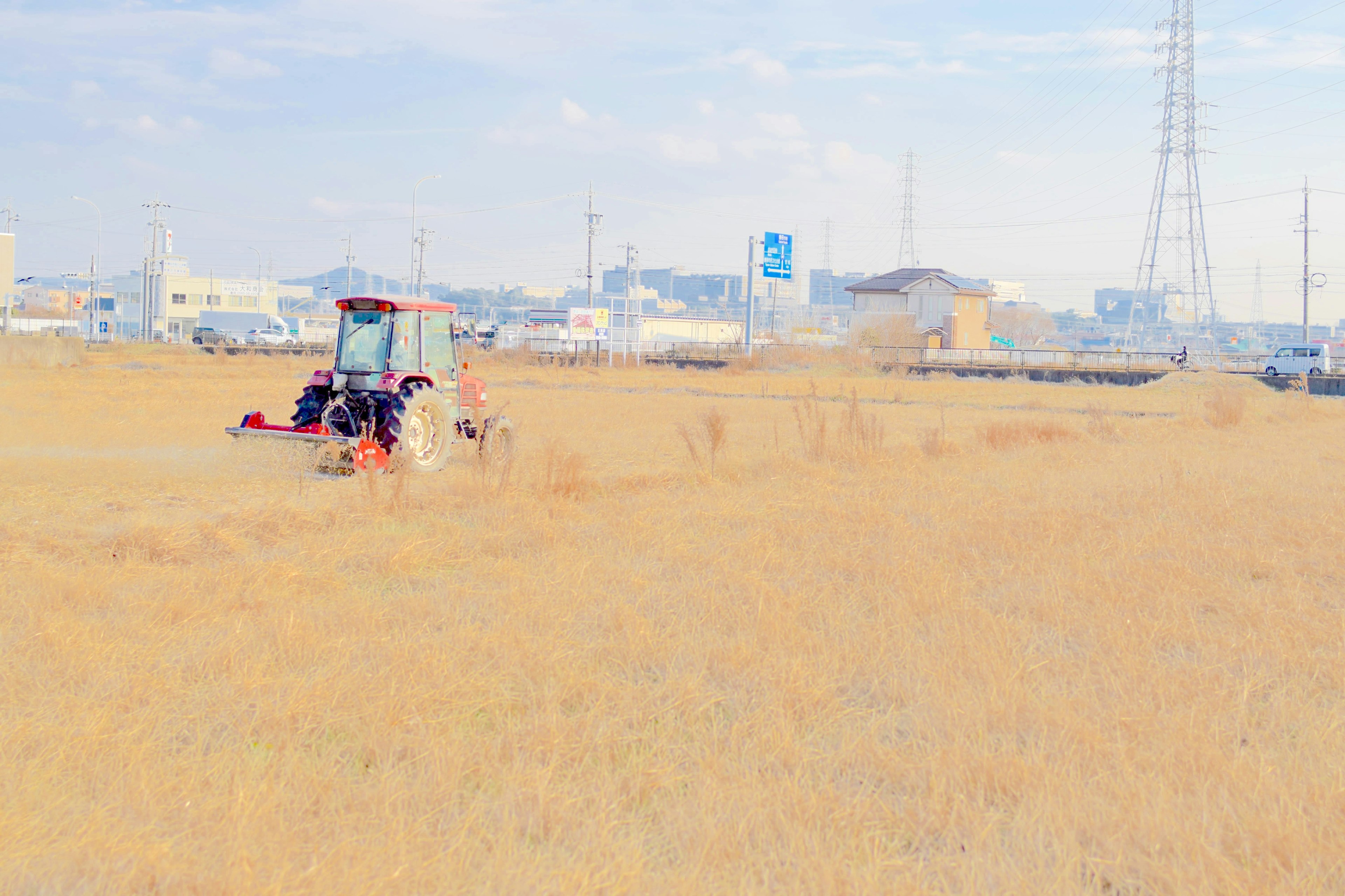 Traktor arbeitet in einem goldenen Feld unter klarem Himmel